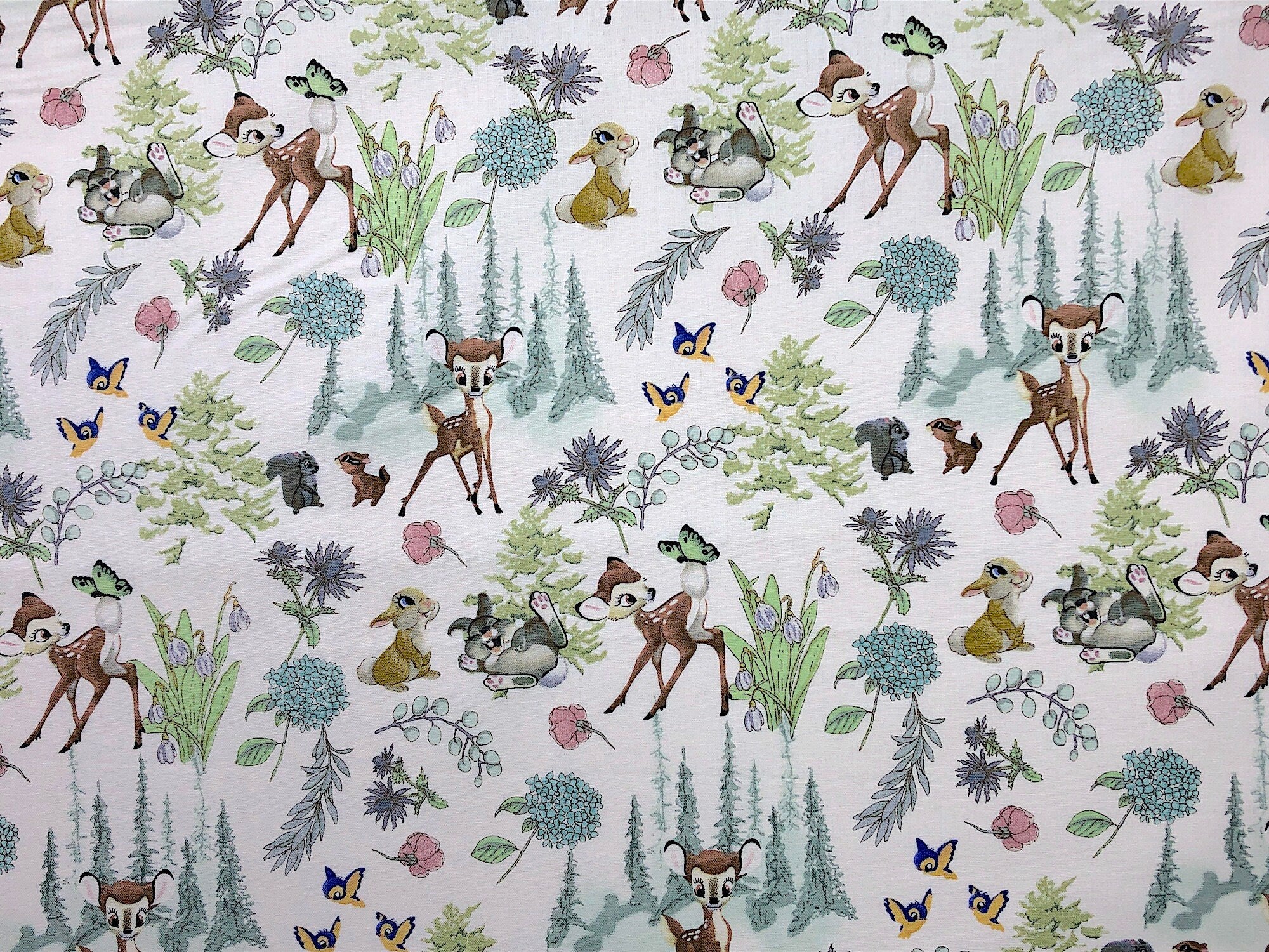 This fabric is called Bambi and Friends. The white fabric is covered with deer, birds, squirrels, flowers and leaves.