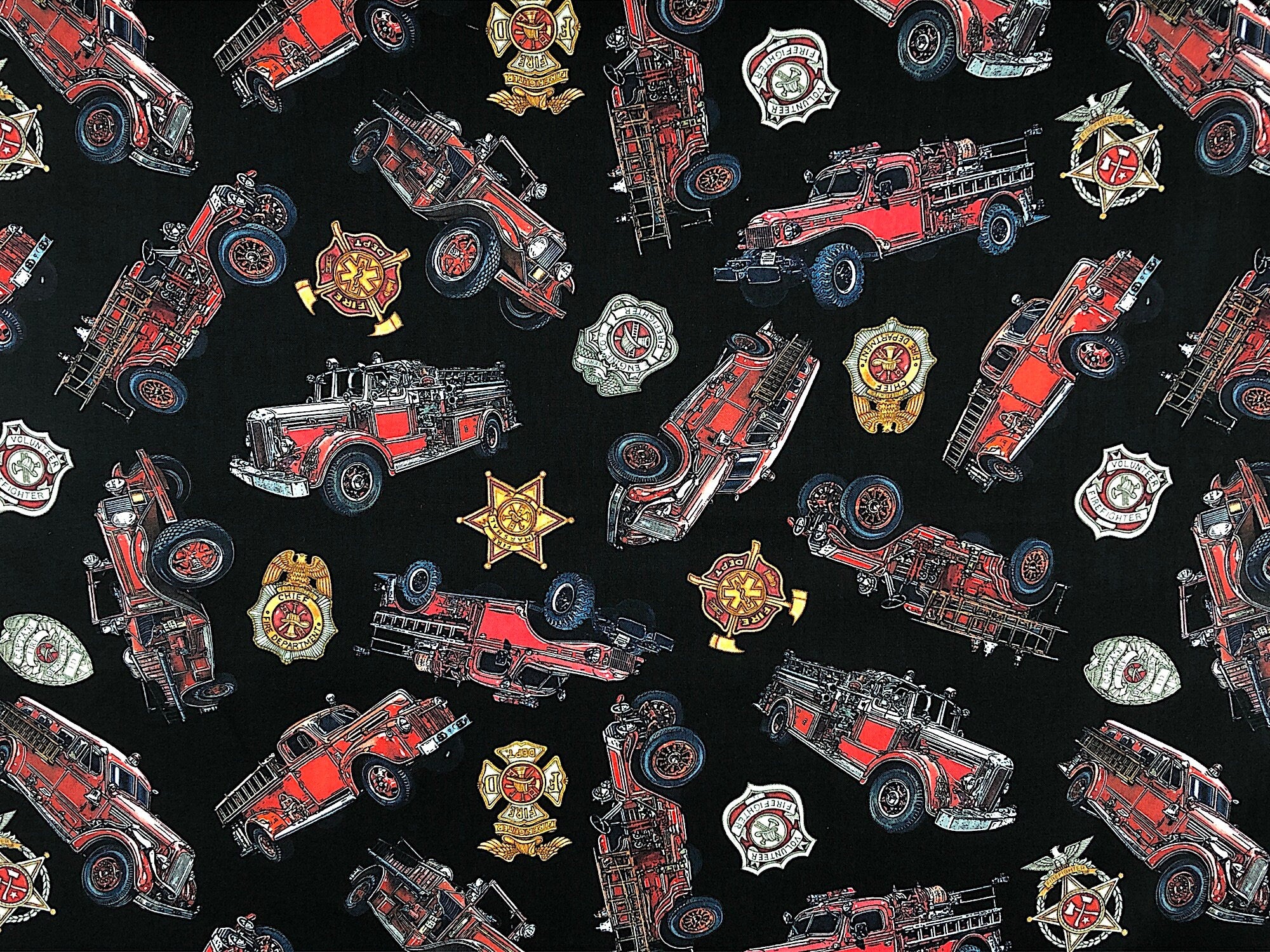 This black fabric is part of the 5 Alarm collection and is covered with firetrucks and shields.