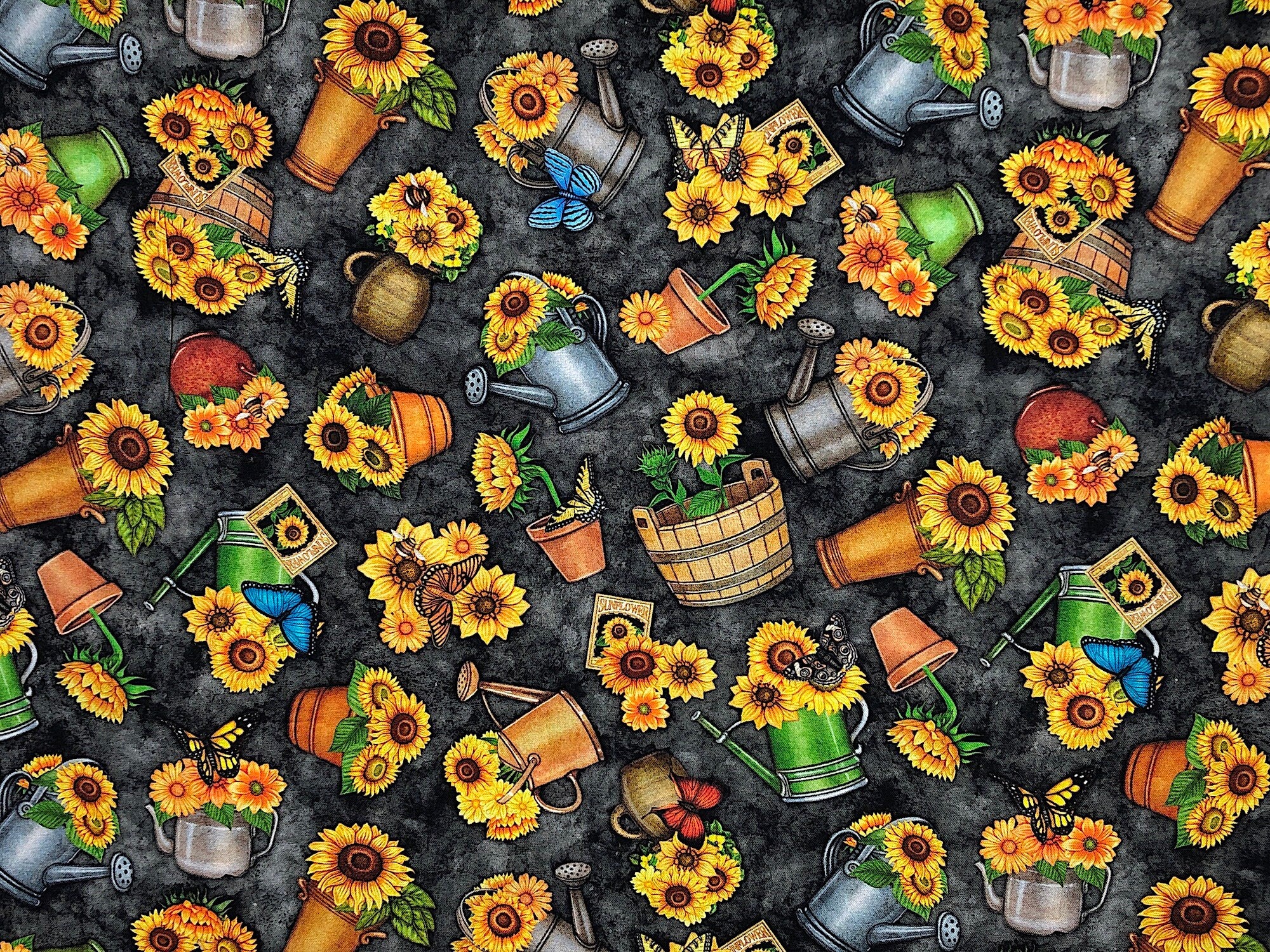 This fabric is part of the Always Face Sunshine Collection. There are watering cans and flower pots full of sunflowers. You will also find seed packets and butterflies throughout the fabric. The background is black.
