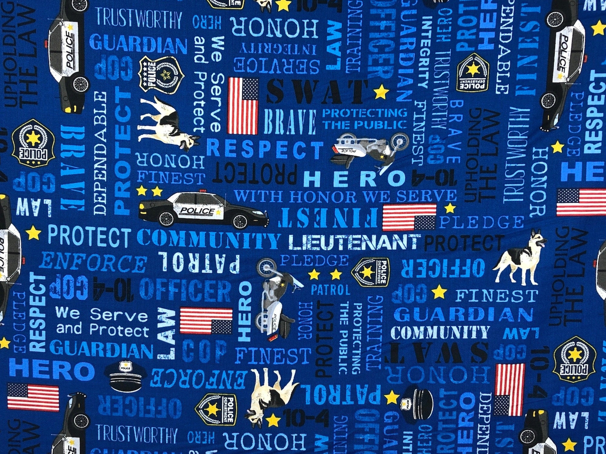 This blue fabric is covered with police cars, motorbikes and USA Flags. You will also find the following words, pledge, officer, protect, community, guardian, law, we serve and protect and more.
