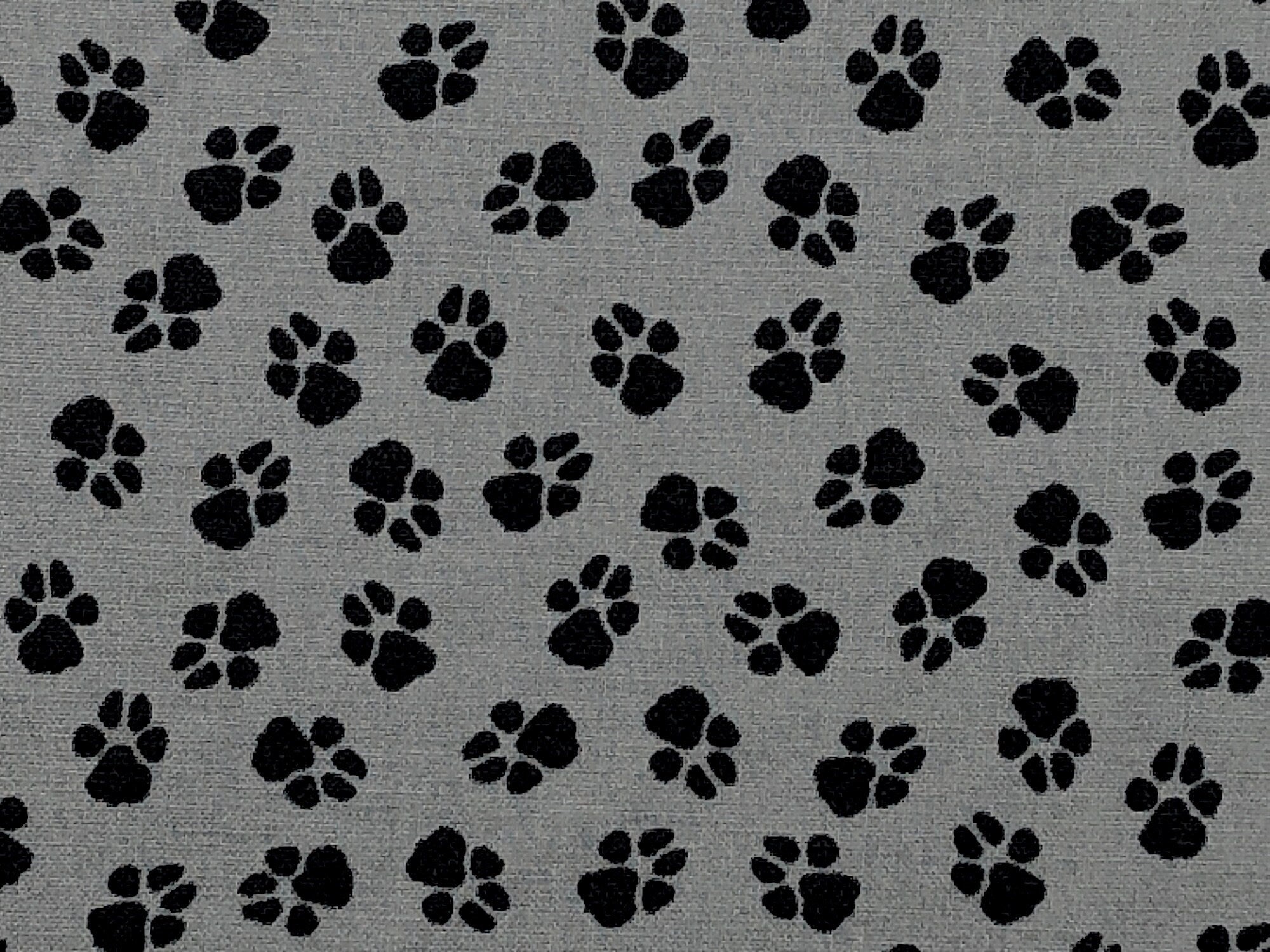 Close up of paw prints on grey cotton fabric.
