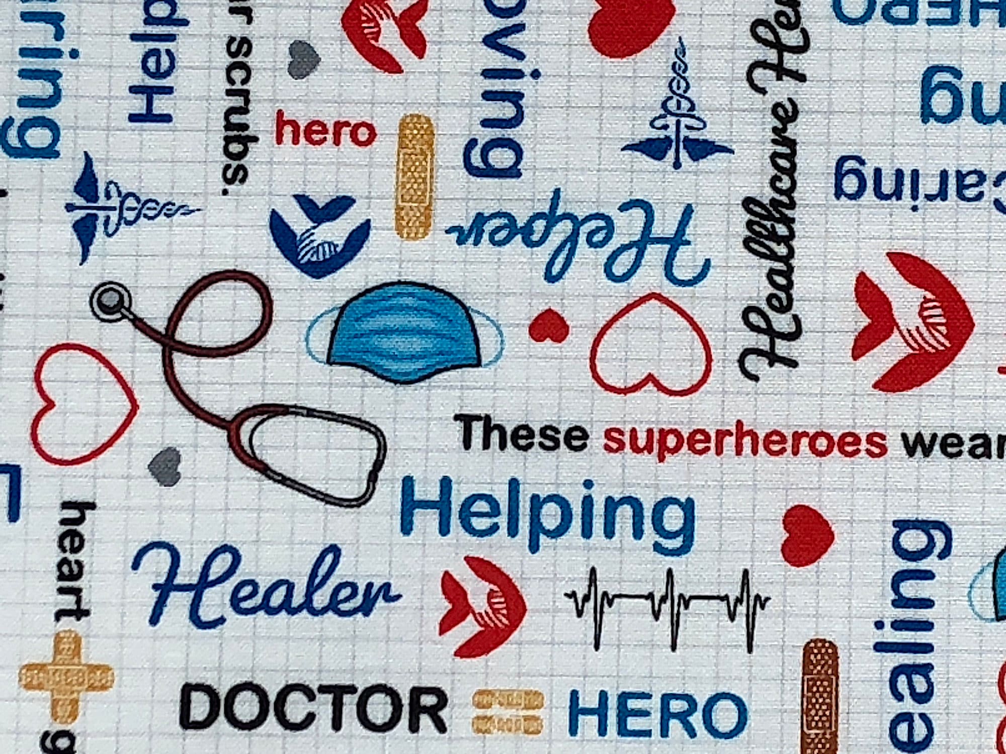 Close up of face masks, stethoscopes, words such as helping, healer, doctor, hero and more.