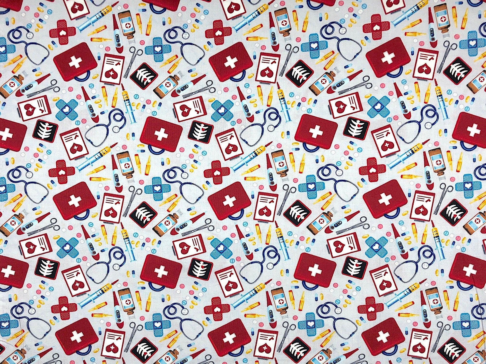 This fabric is part of the big hugs collection. The grey fabric is covered with first aid kit essentials. You will find scissors, band-aids, syringes, stethoscopes, patient charts and more.