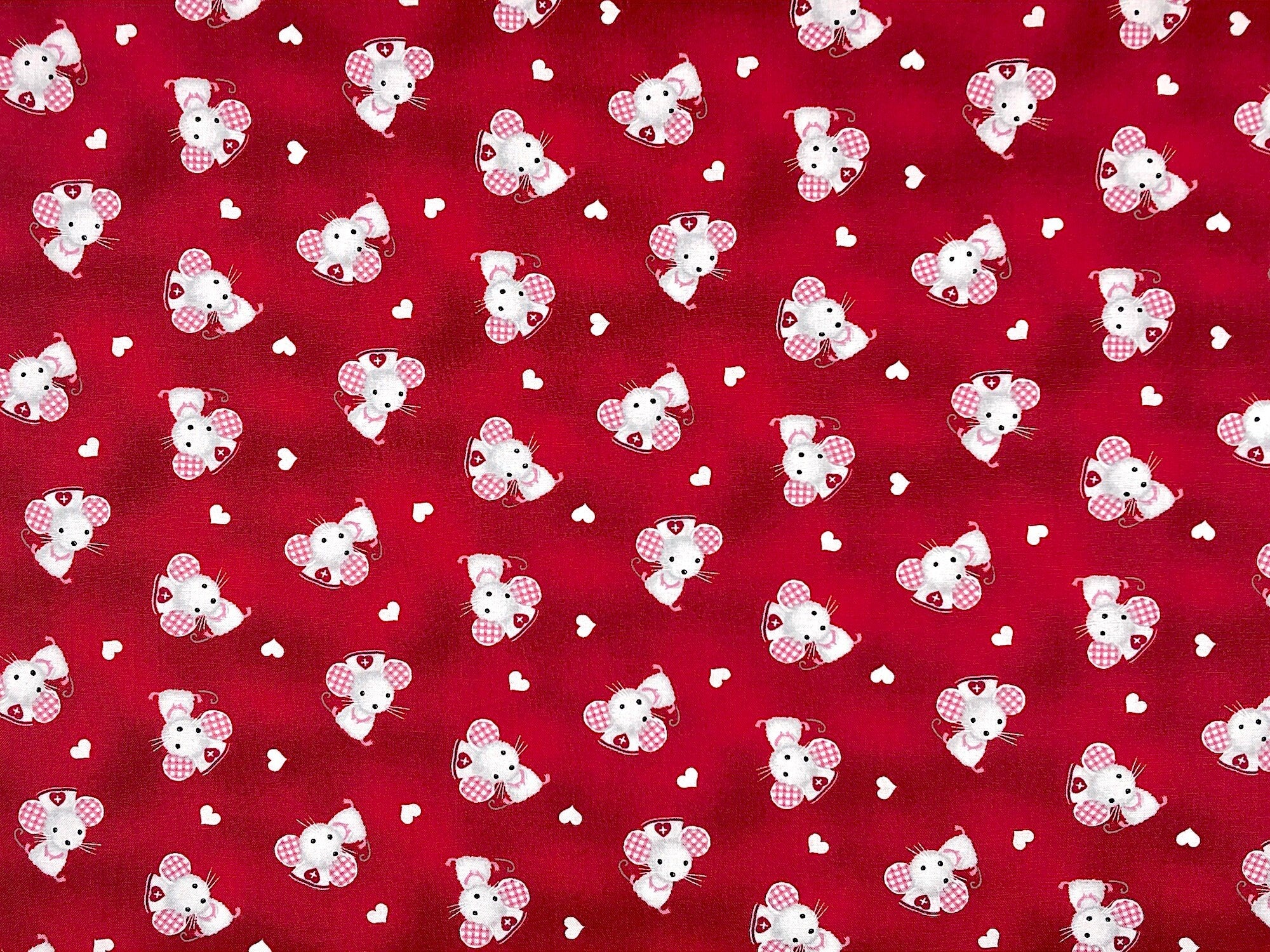 The red fabric is covered with Mice that are wearing nurse caps. This fabric is part of the big hugs collection.