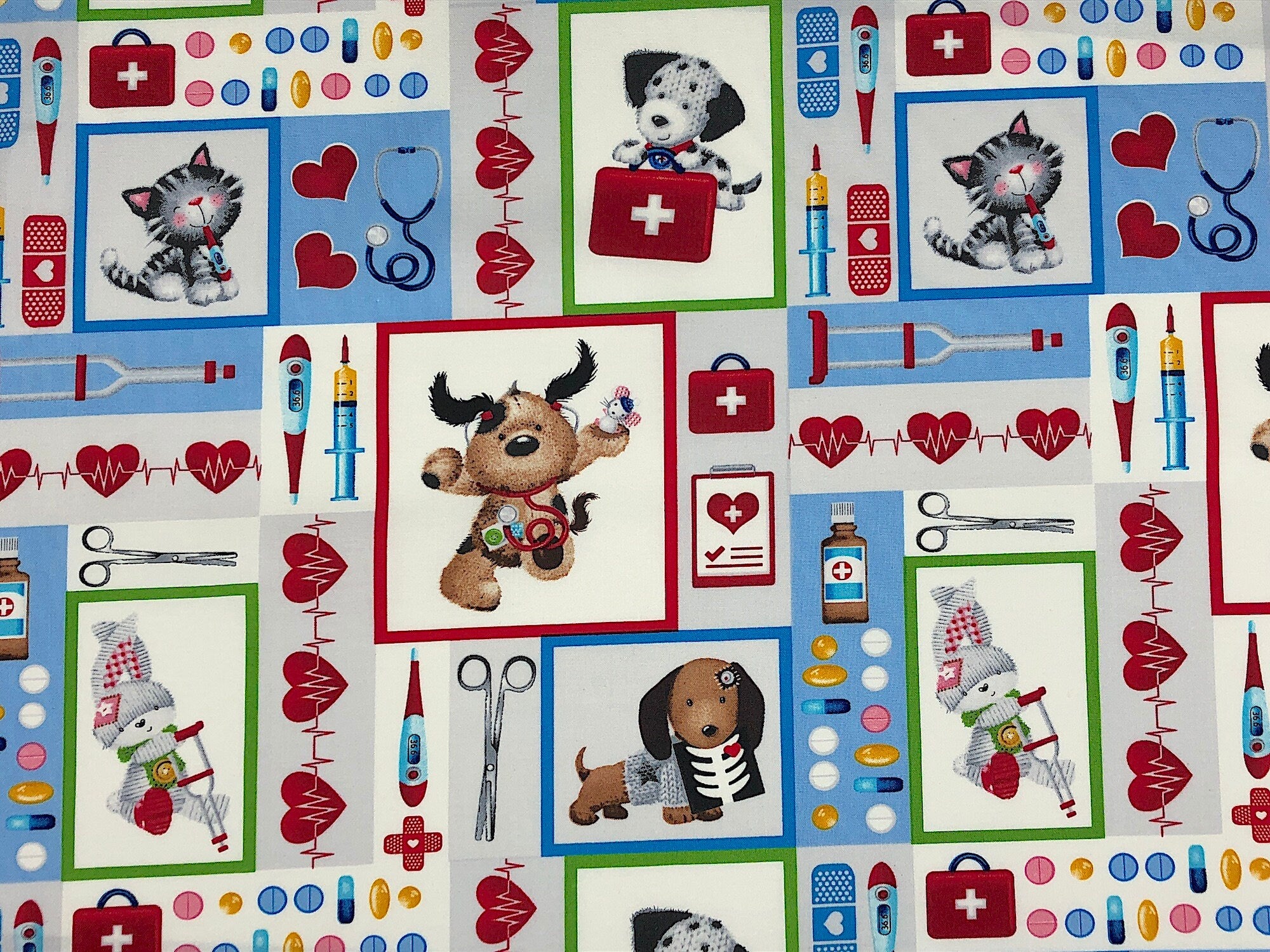 The white fabric is covered with cats and dogs, first aid kits, hearts, medicine, crutches, stethoscopes and more. Some of the dogs have stethoscopes around their neck. This fabric is part of the big hugs collection.