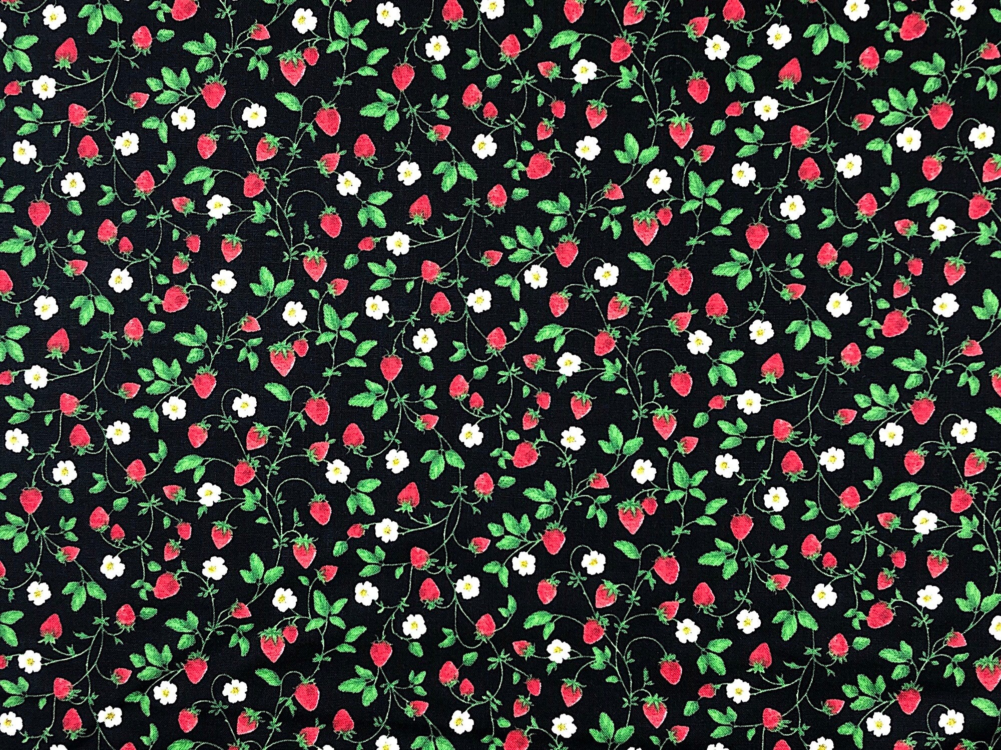 This black fabric is covered with small strawberries on the vine. The vines also have flowers and leaves on them. This fabric is part of the Strawberry Fields Collection