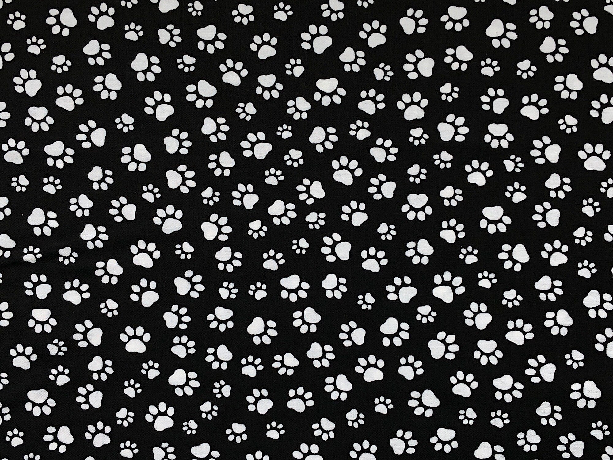 Black cotton fabric covered with white paw prints.