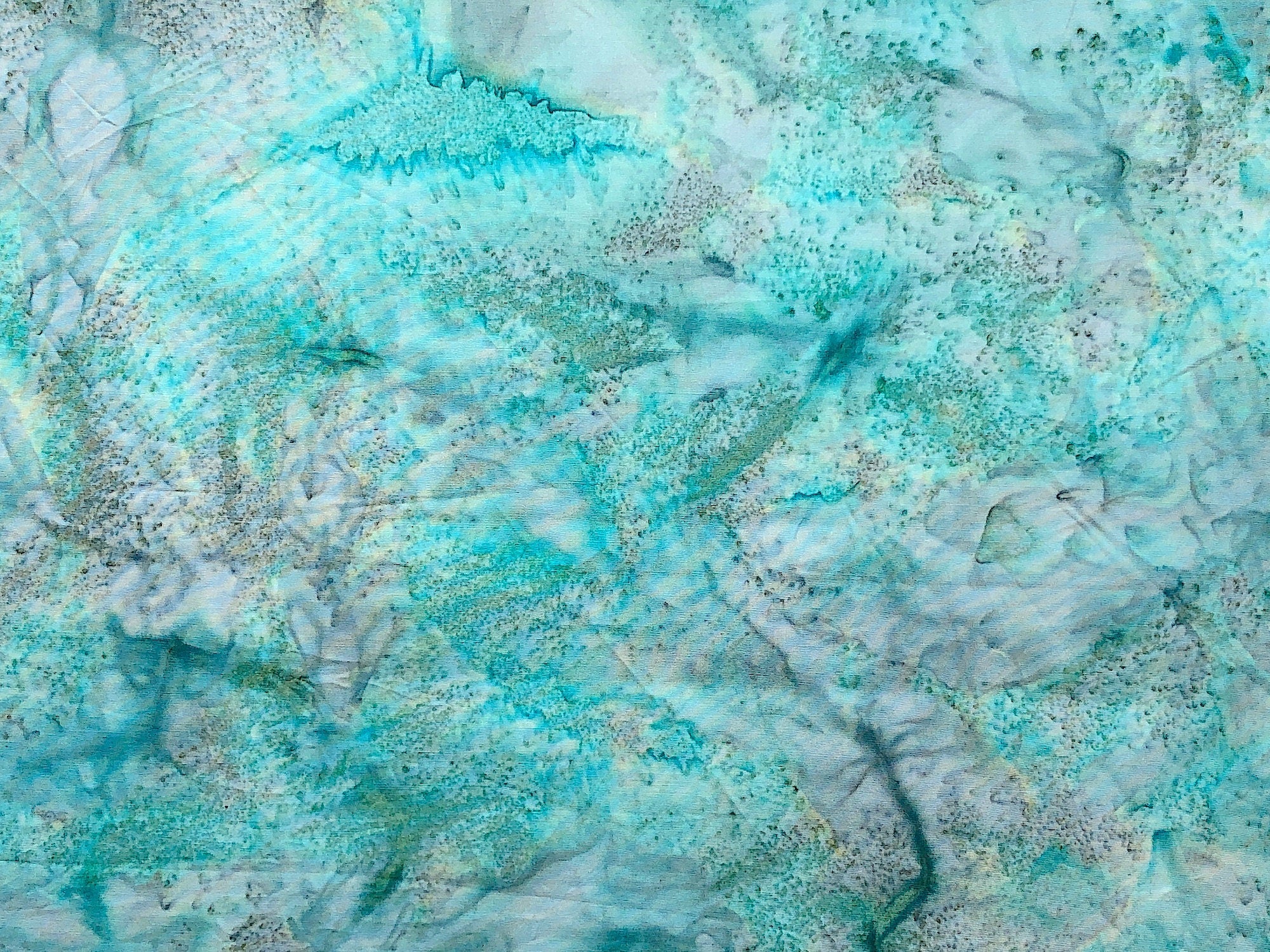 Cotton fabric covered with shades of aqua, grey and white .