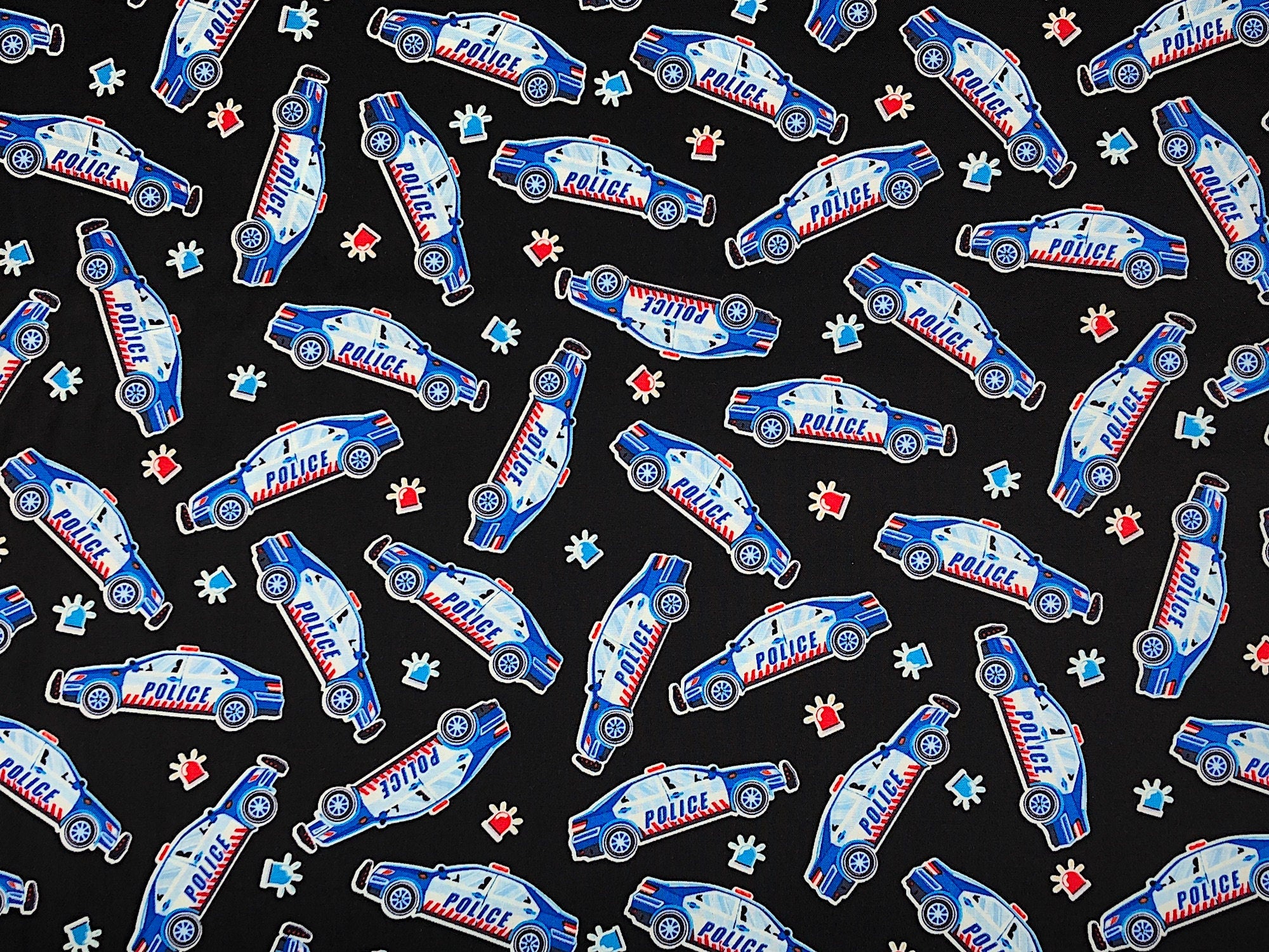 This fabric is called Police Cars Black and is covered with Police Cars. The blue background also has orange cones scattered throughout. This fabric is part of the Save the Day Collection.