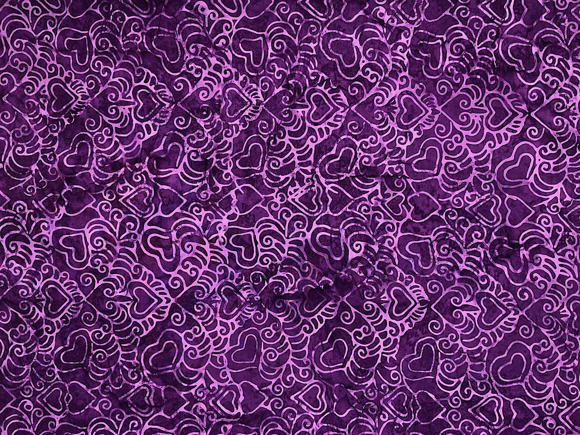 This purple fabric is covered with purple hearts.