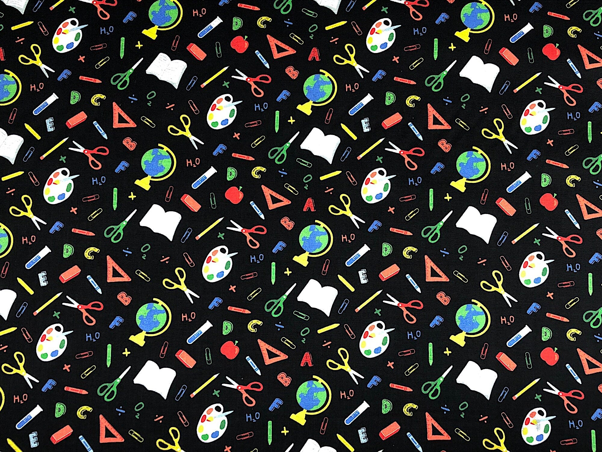This black cotton fabric is covered with crayons, alphabet letters, scissors, world globes, paperclips and more. This fabric is called Teachers Rule Back to School.