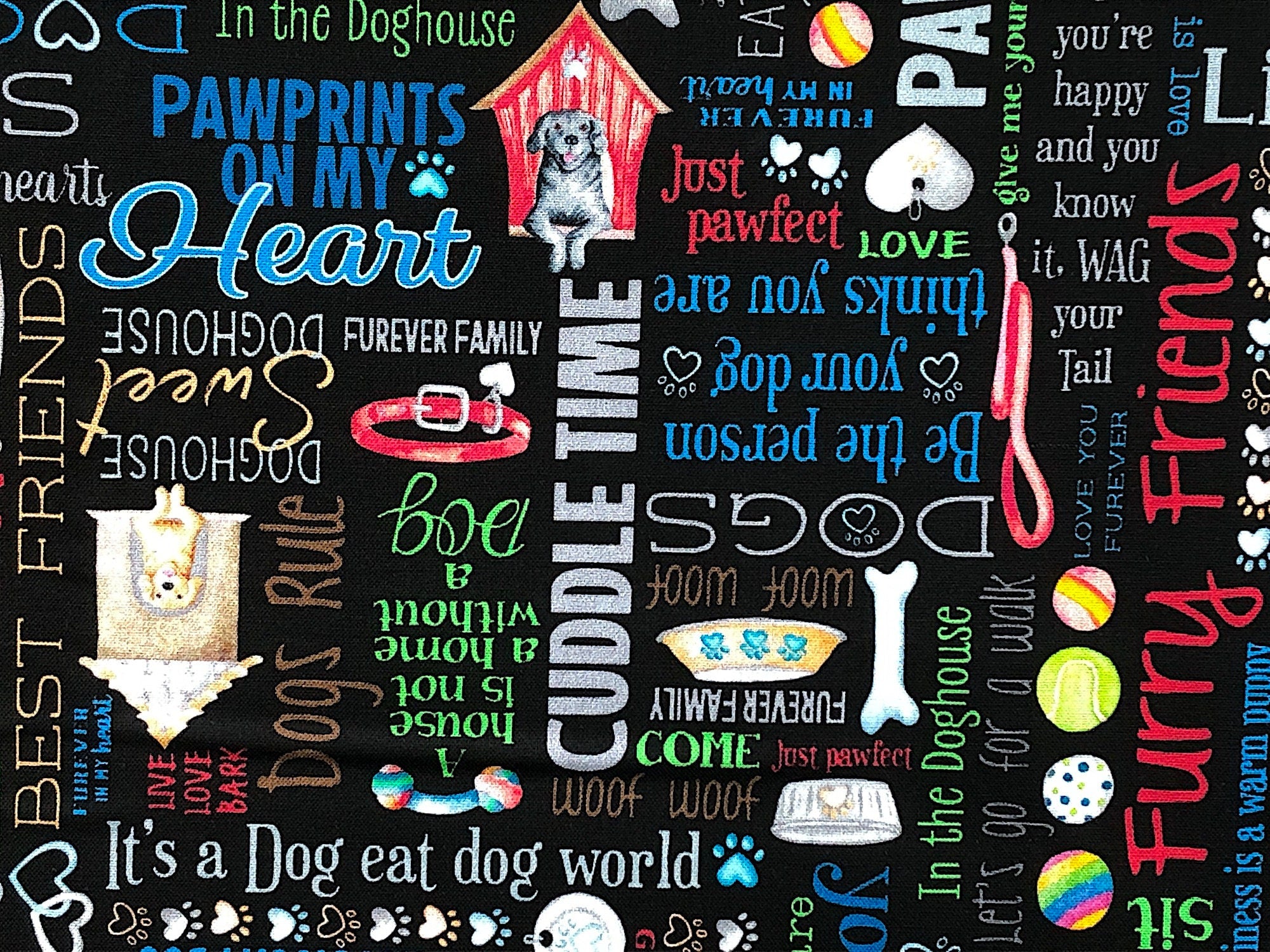 This black fabric is covered with dog sayings such as wag your tail, fetch, life of the dog, hot diggity dog, furry and more.