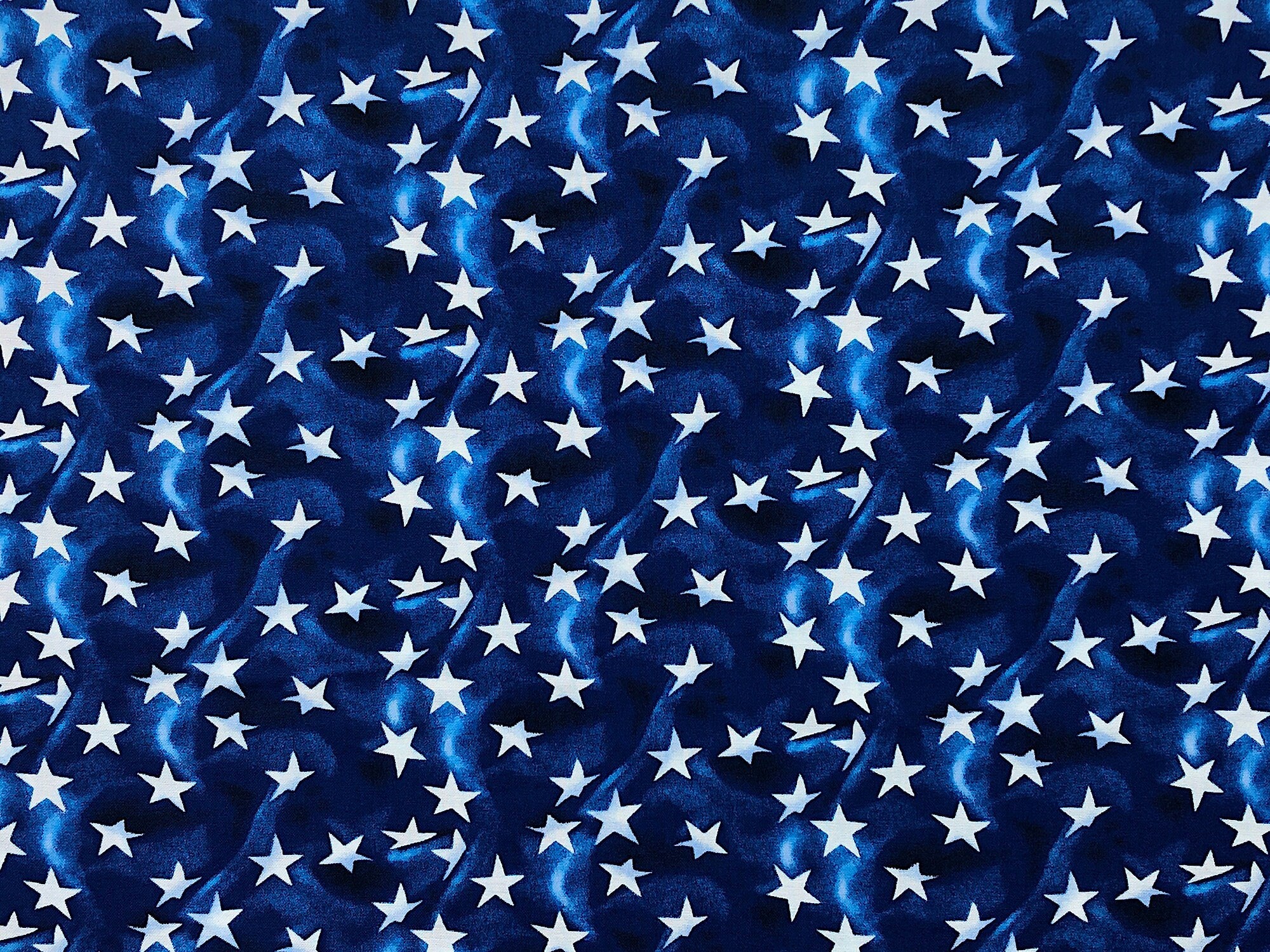 This blue fabric is covered with white stars. This fabric is part of the American Truckers Collection.