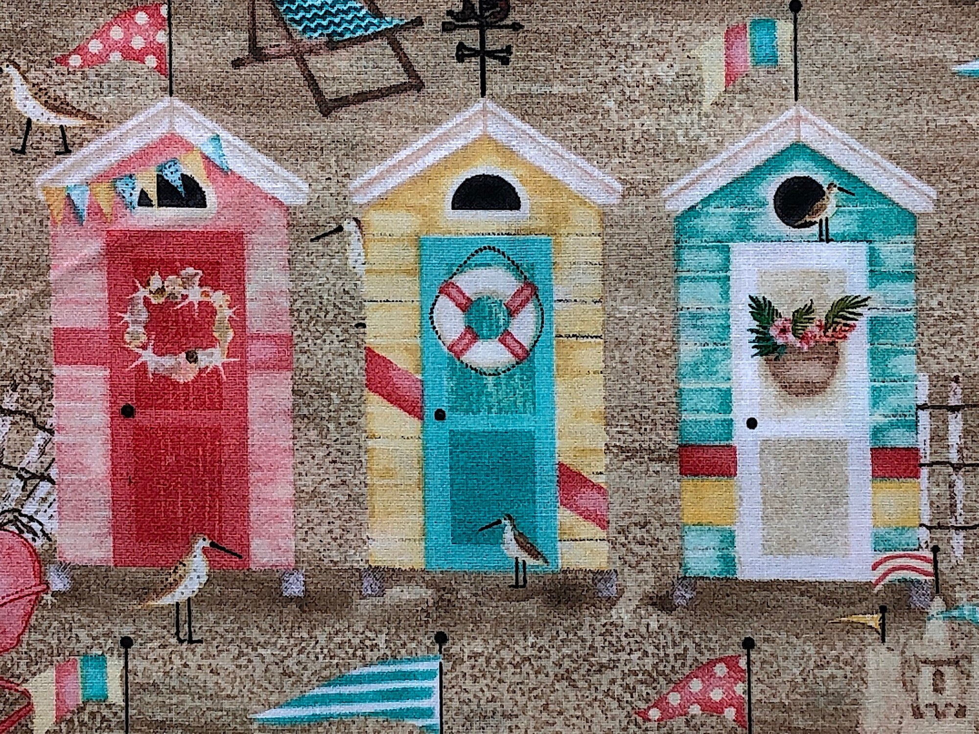 Close up of beach huts, birds, chairs and more.