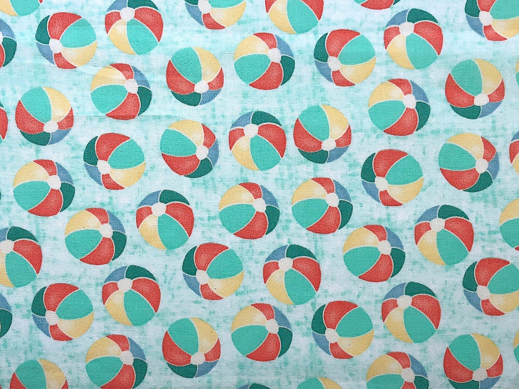 This nautical fabric is covered with beach balls. The beach balls are yellow, green and peach and white. This fabric is part of the Beach Travel Collection by Beth Albert.