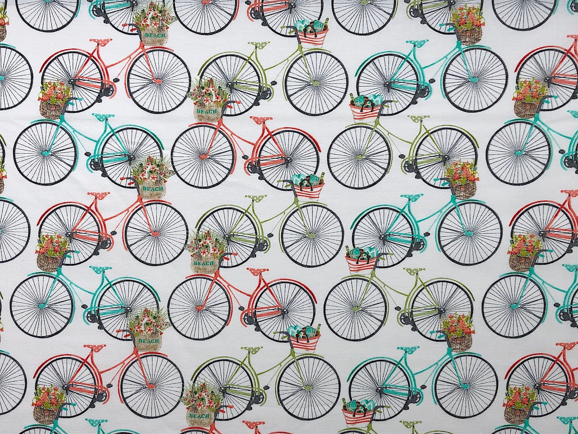 This nautical fabric is covered with teal, peach and green bicycles. The bicycles have baskets that say beach on them and the baskets are filled with flowers. This fabric is part of the Beach Travel Collection by Beth Albert.