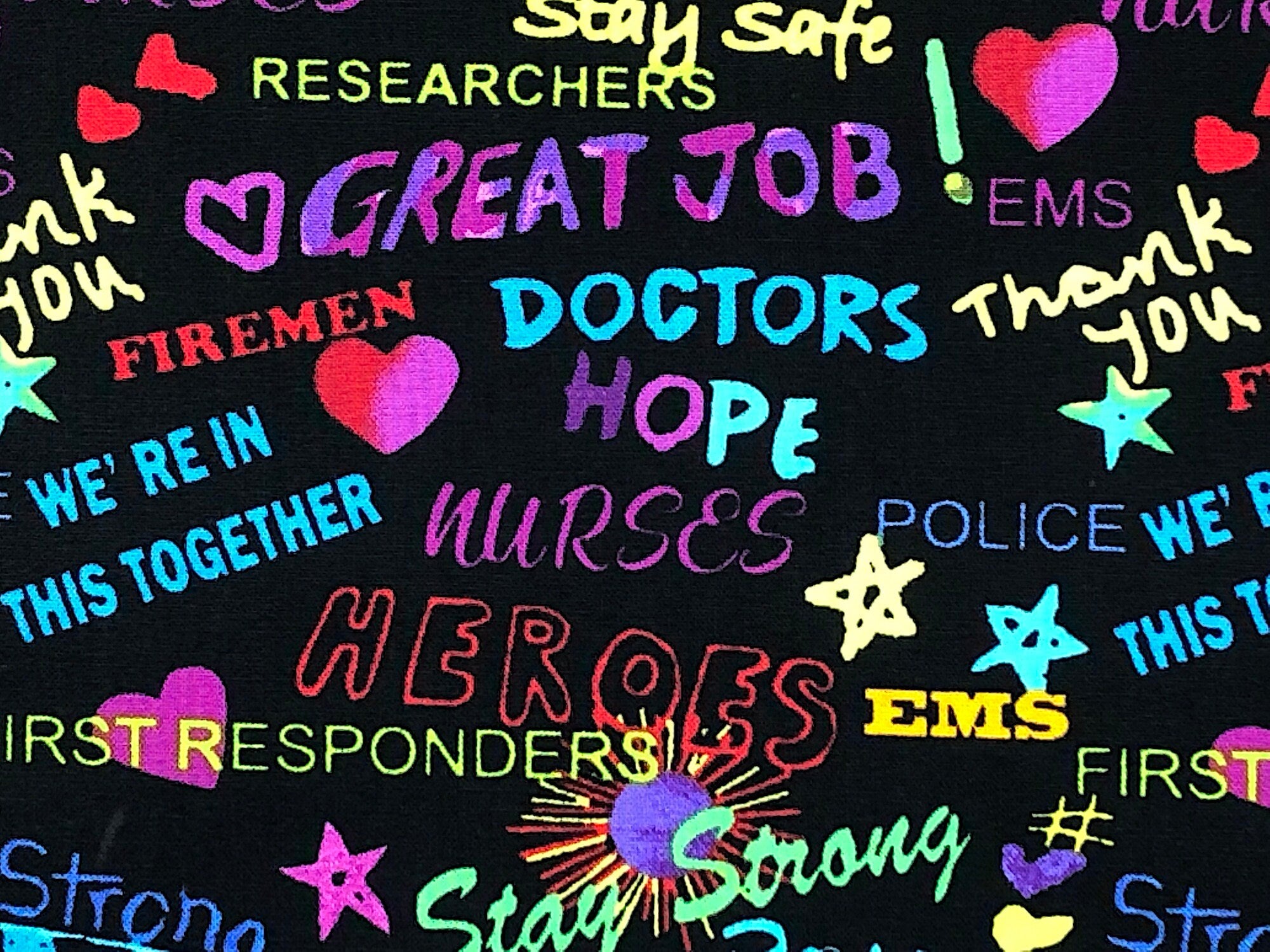 This black fabric is covered with hero sayings such as we're in this together, stay strong, nurse, heroes, police and more.