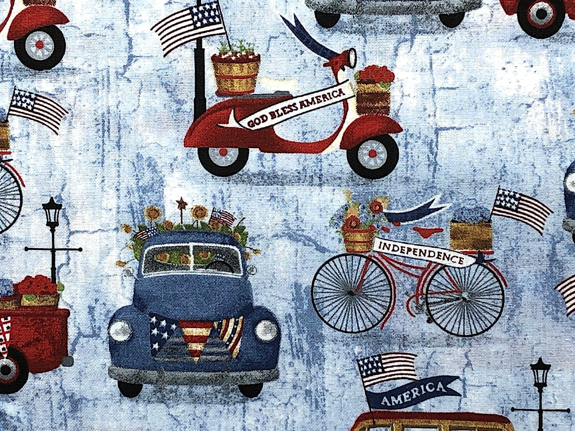 Close up of a blue truck, bicycle, flowers USA flags and more.