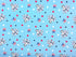 Light blue cotton fabric covered with red, white and blue stars and snoopy dancing.