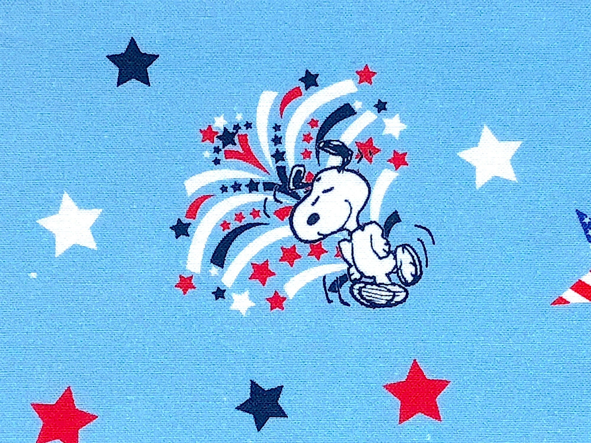 Close up of Snoopy dancing surrounded by red, white and blue stars.
