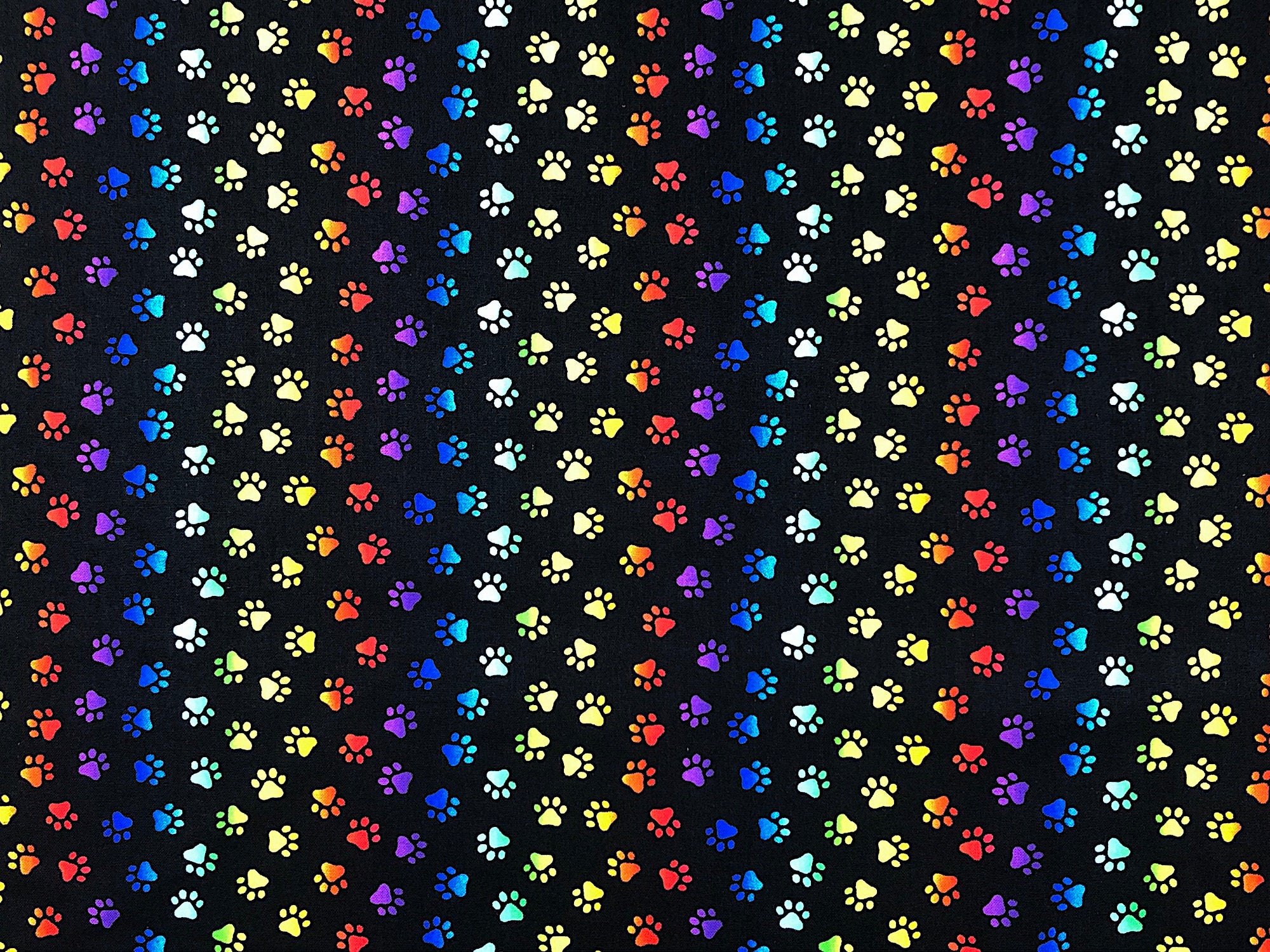 This fabric is called Neon Cat Paw prints. This black fabric is covered with red, orange, yellow, green, blue and purple paw prints.