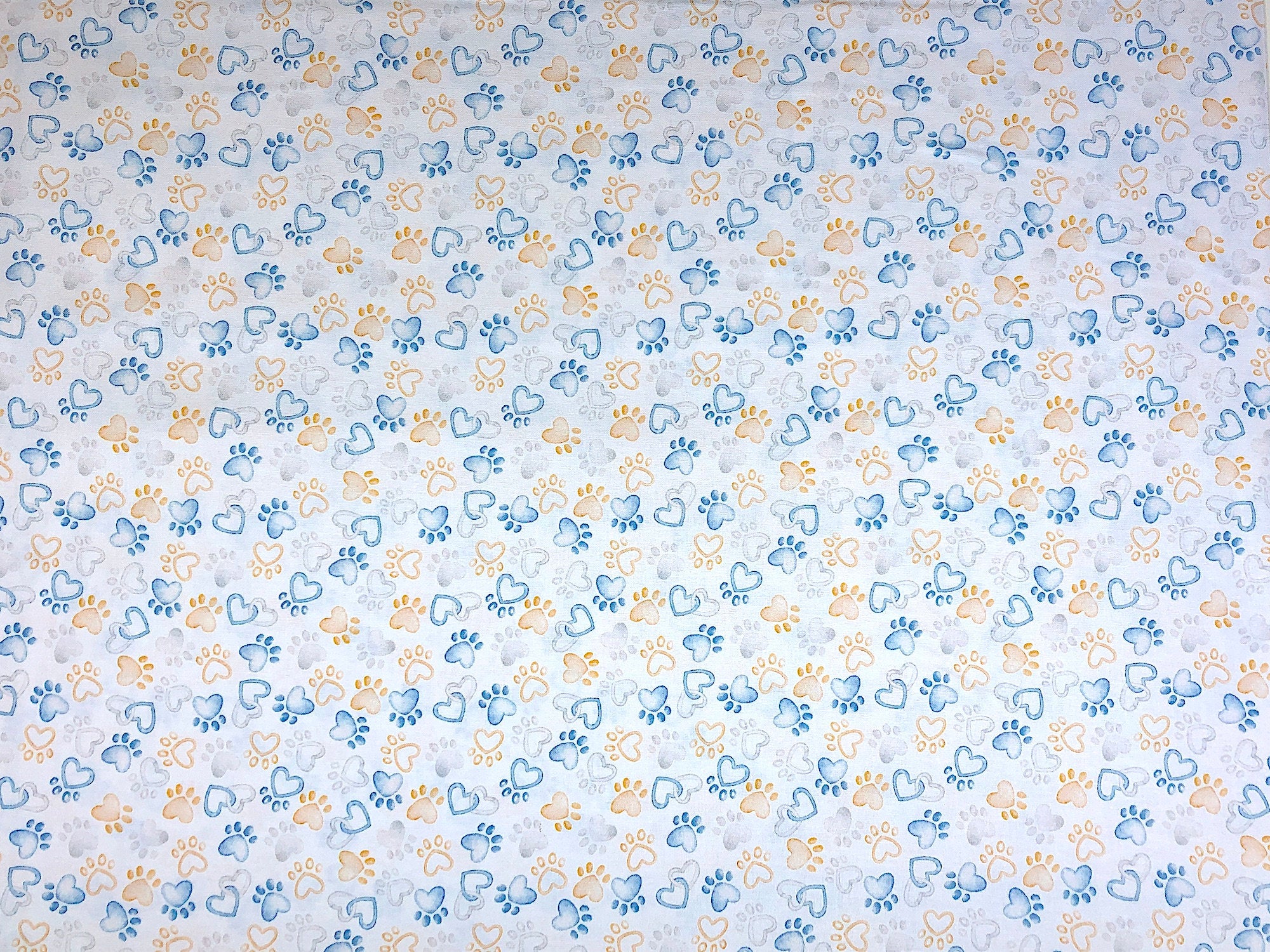 This white fabric is covered with paw prints and hearts.