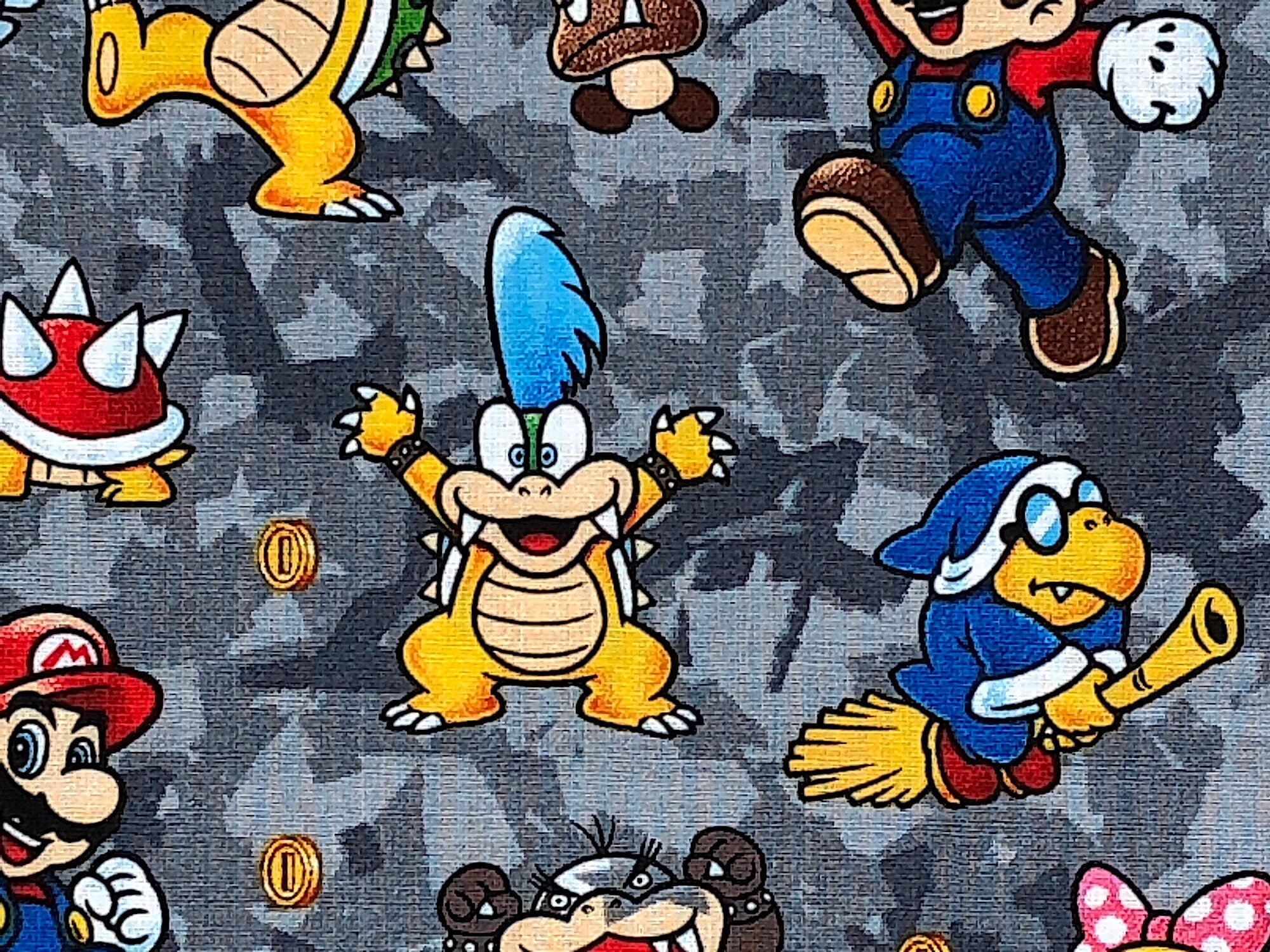 This gray fabric is covered with Super Mario characters such as Mario and Bowser.
