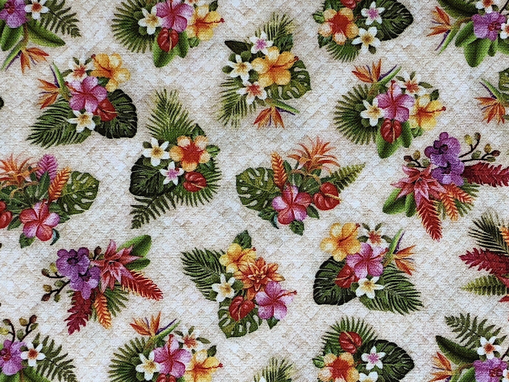 This fabric is a pretty tropical floral print with a light beige background. There are small flowers in groupings along with ferns and leaves.