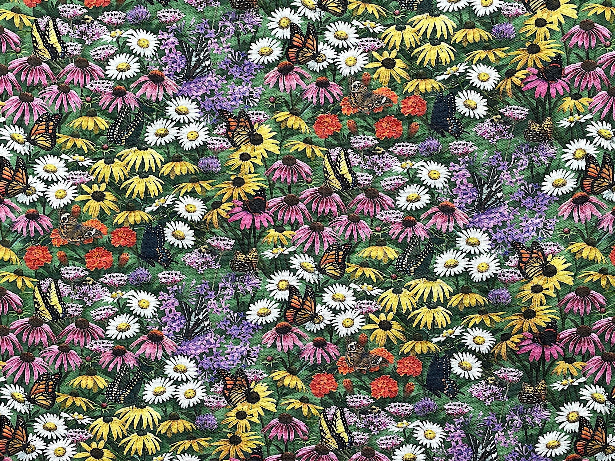 Cotton fabric covered with a field of flowers with butterflies on flowers.