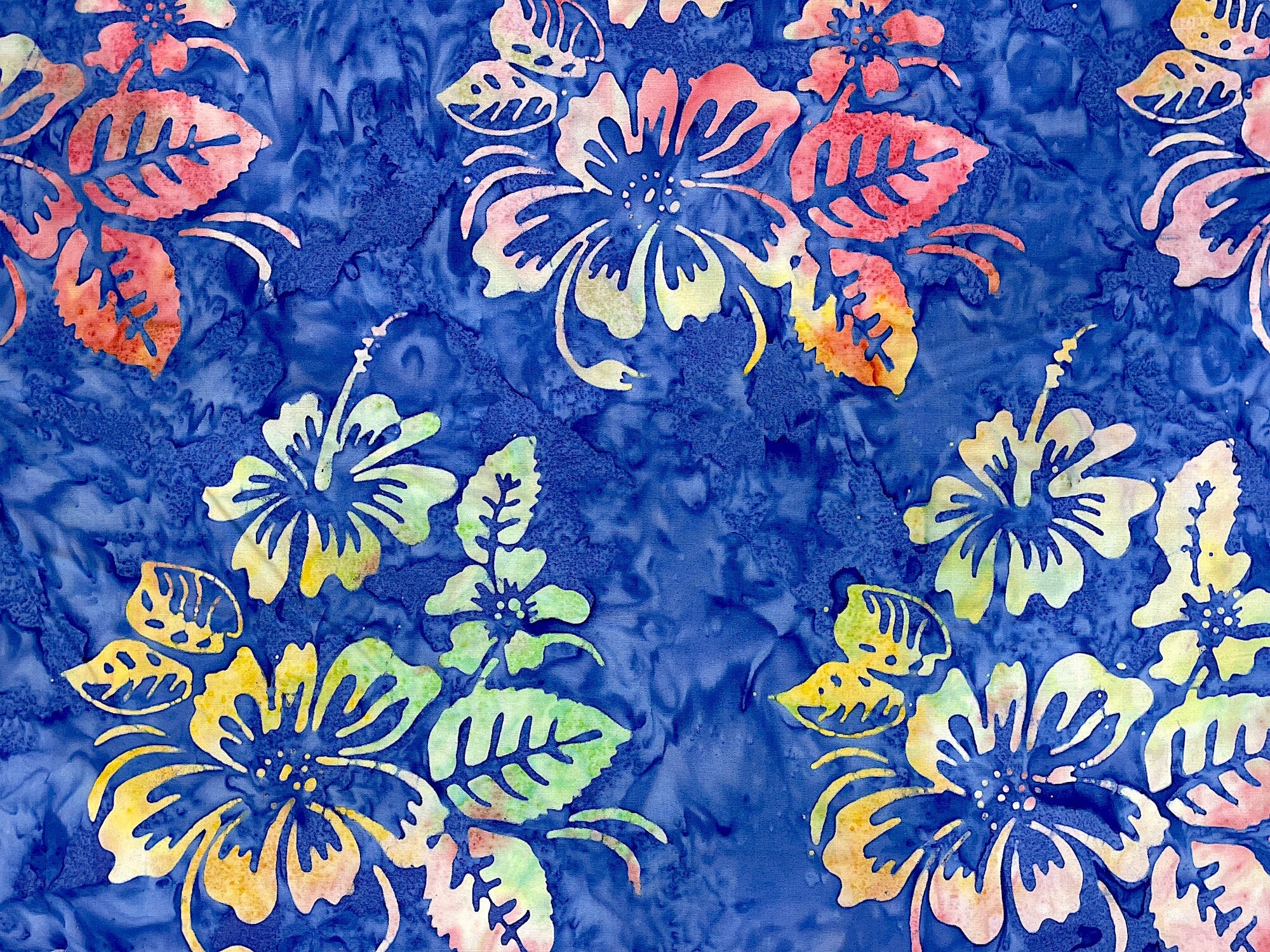 Blue batik fabric covered with hibiscus.