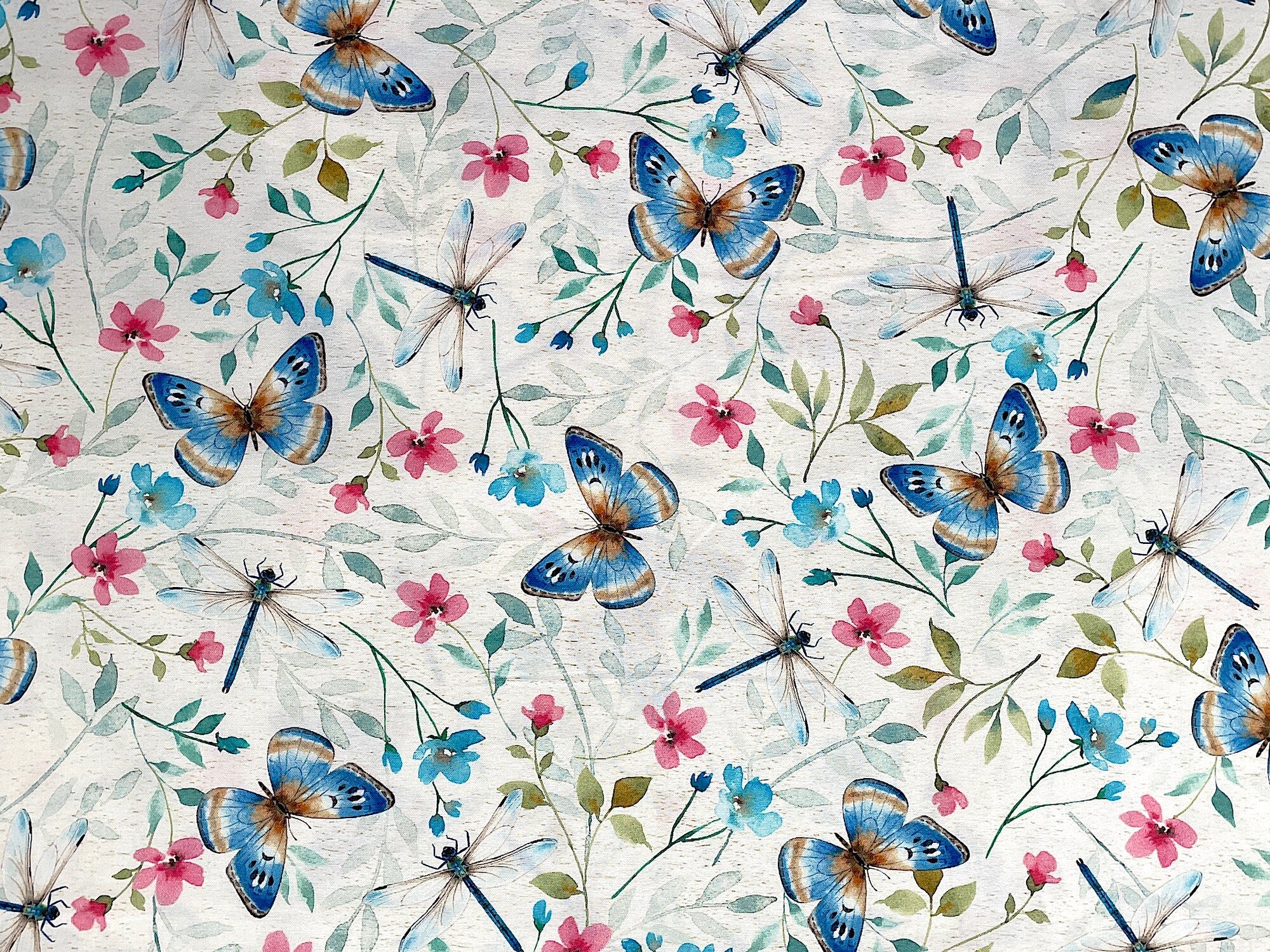 Cream fabric covered with butterflies, dragonflies and flowers.