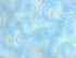 This blue fabric is part of the Dragonfly Dance collection and is covered with swirls that are white or blue. You will also find starts and dots of gold throughout the fabric.