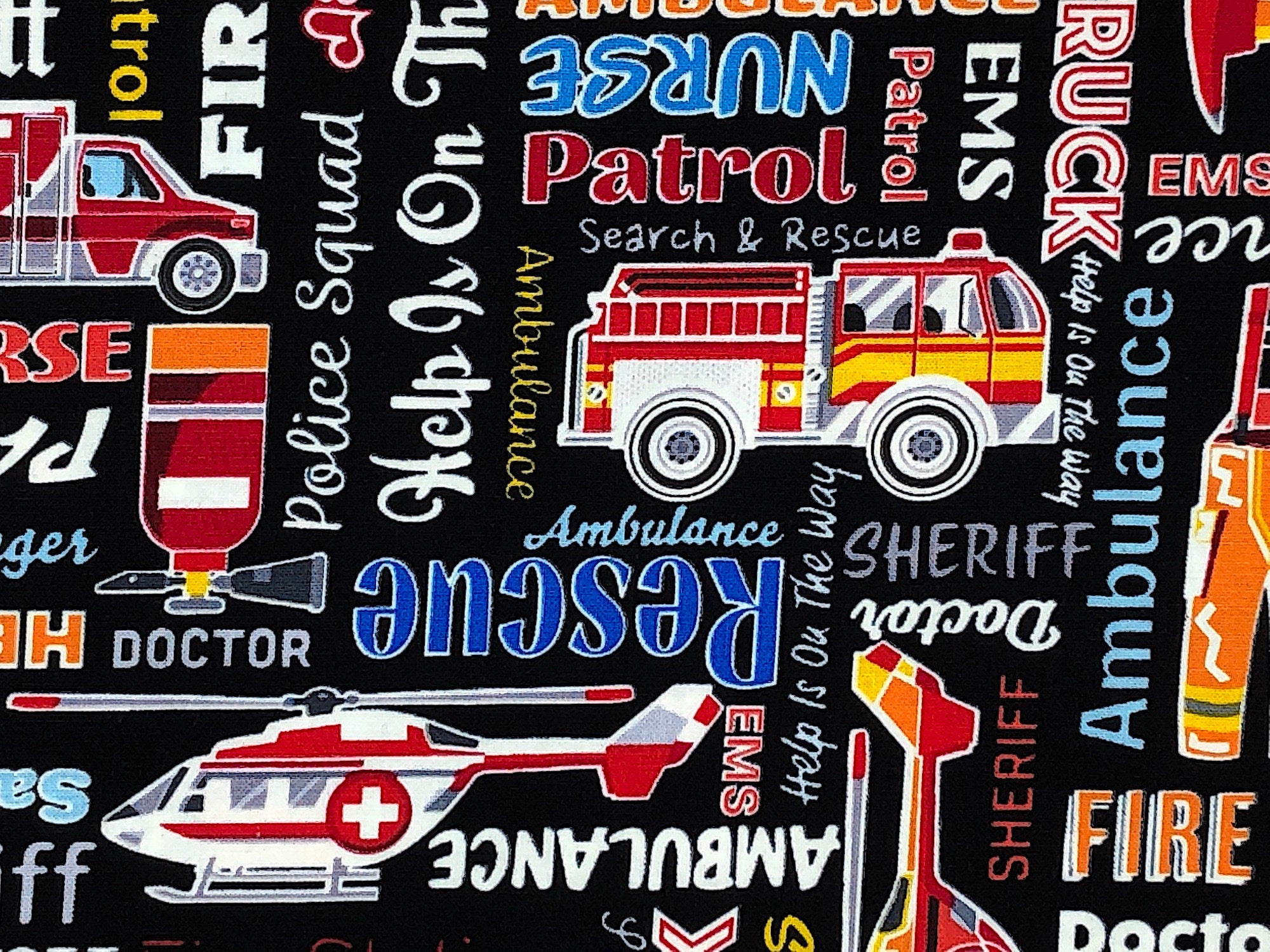 Close up of fire truck and sayings such as rescue, ambulance sheriff, doctor and more.