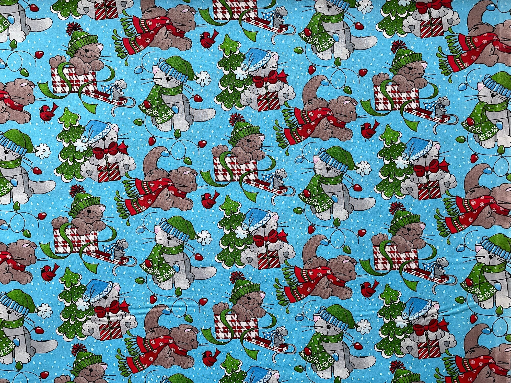 This Christmas fabric is covered with Cats. The cats are looking at birds, playing in boxes, sitting by trees and surrounded by lights.