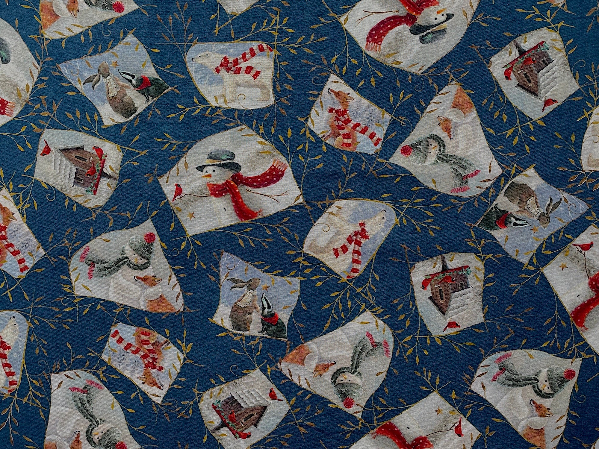This blue fabric is covered with snowmen, bird houses, birds and other wildlife such as bears, bunnies and fox.