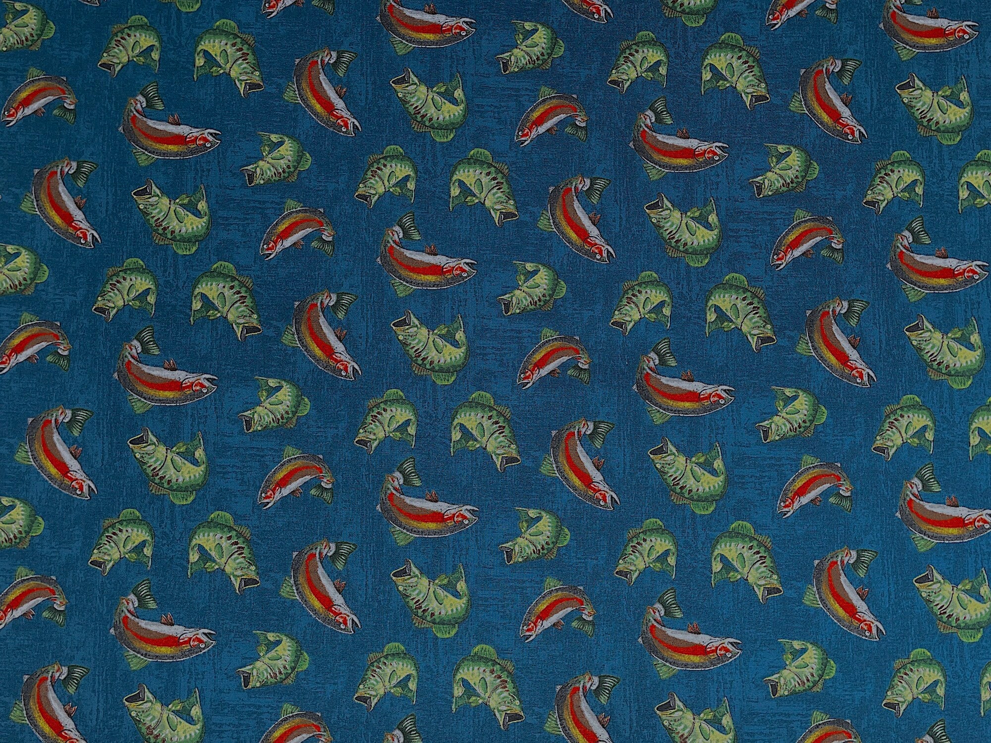 This fabric is covered with fish. Some of the fish are green and others are green, yellow, white and orange. This fabric is part of the Lake Adventure collection by Wilmington Prints.