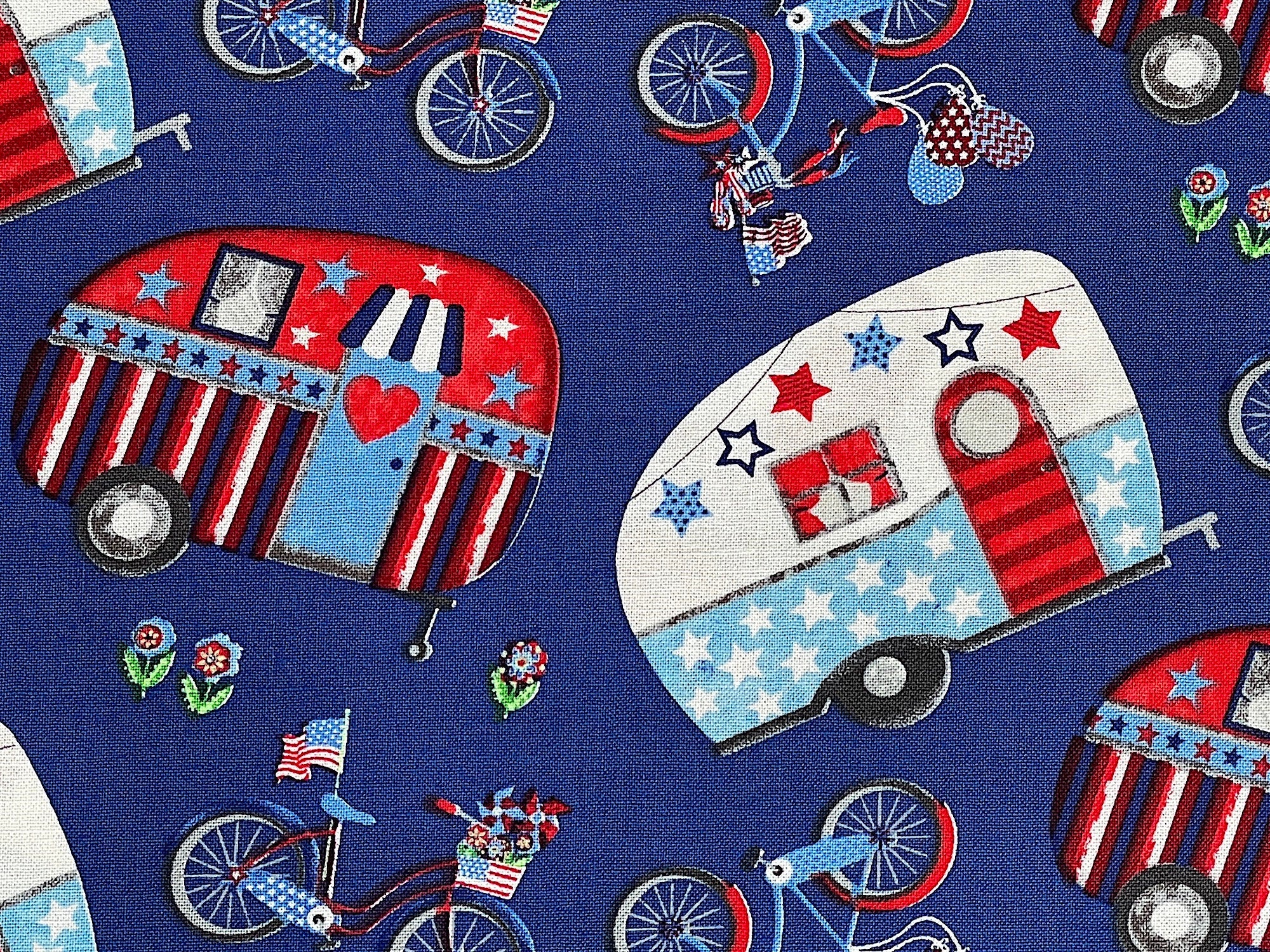Blue cotton fabric covered with red white and blue travel trailers and bicycles.