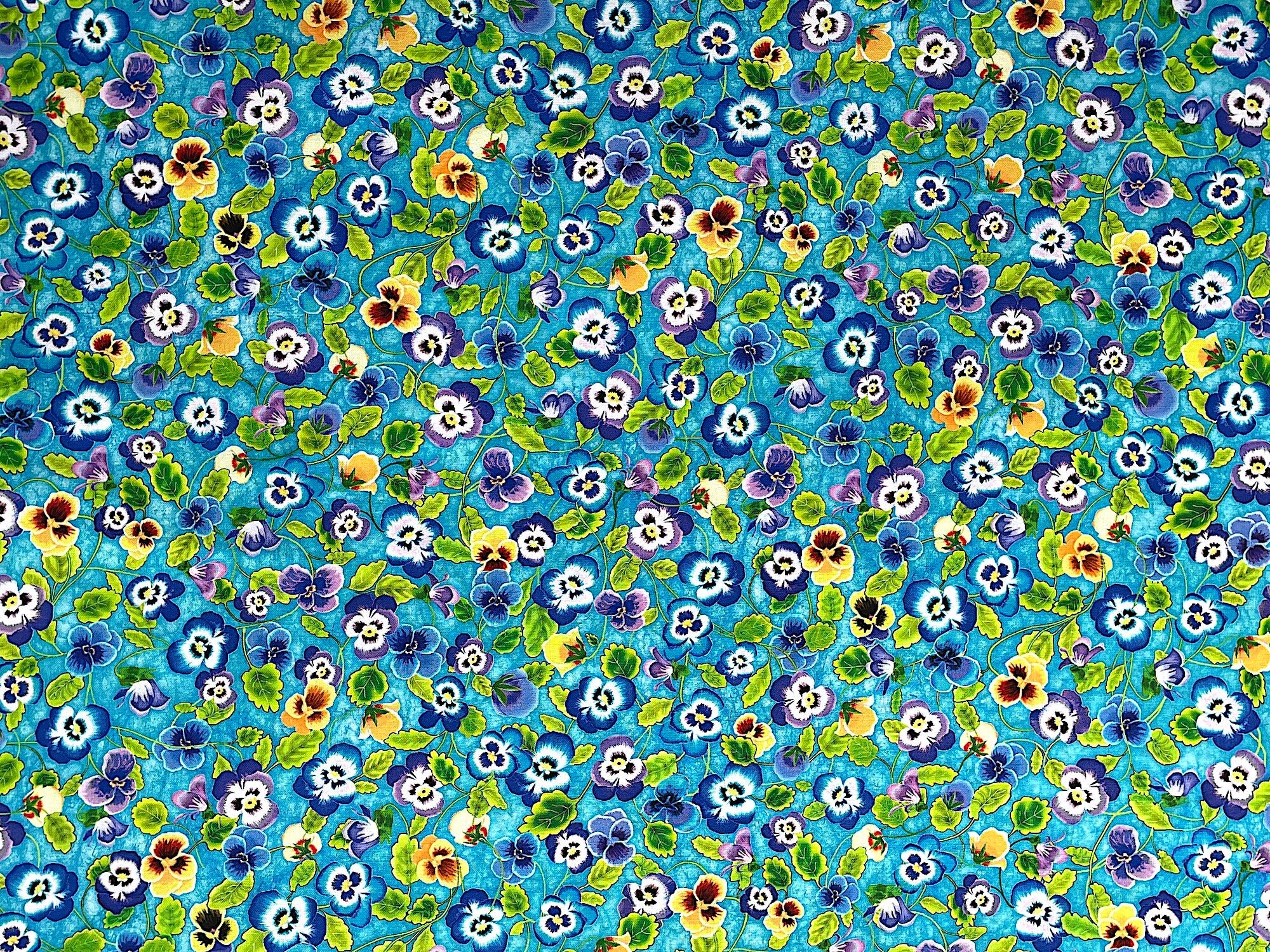 Teal cotton fabric covered with yellow, blue and purple pansies and green leaves.