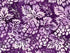 Close up of purple batik fabric featuring grapes and leaves.