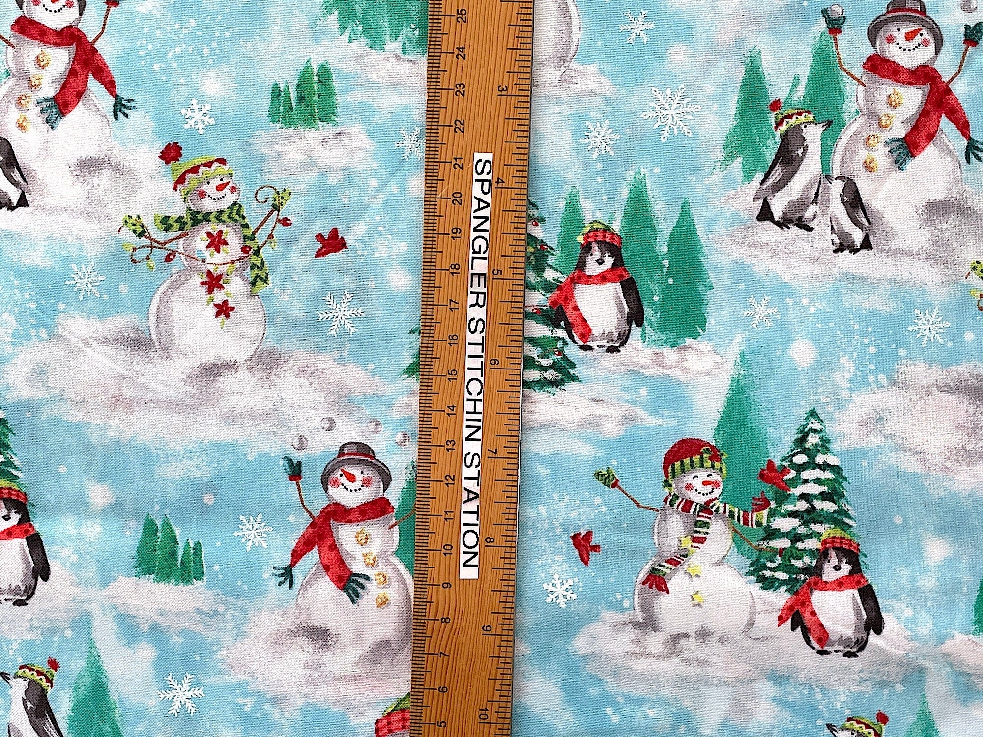 Ruler on fabric to show height of snowmen and penguins.