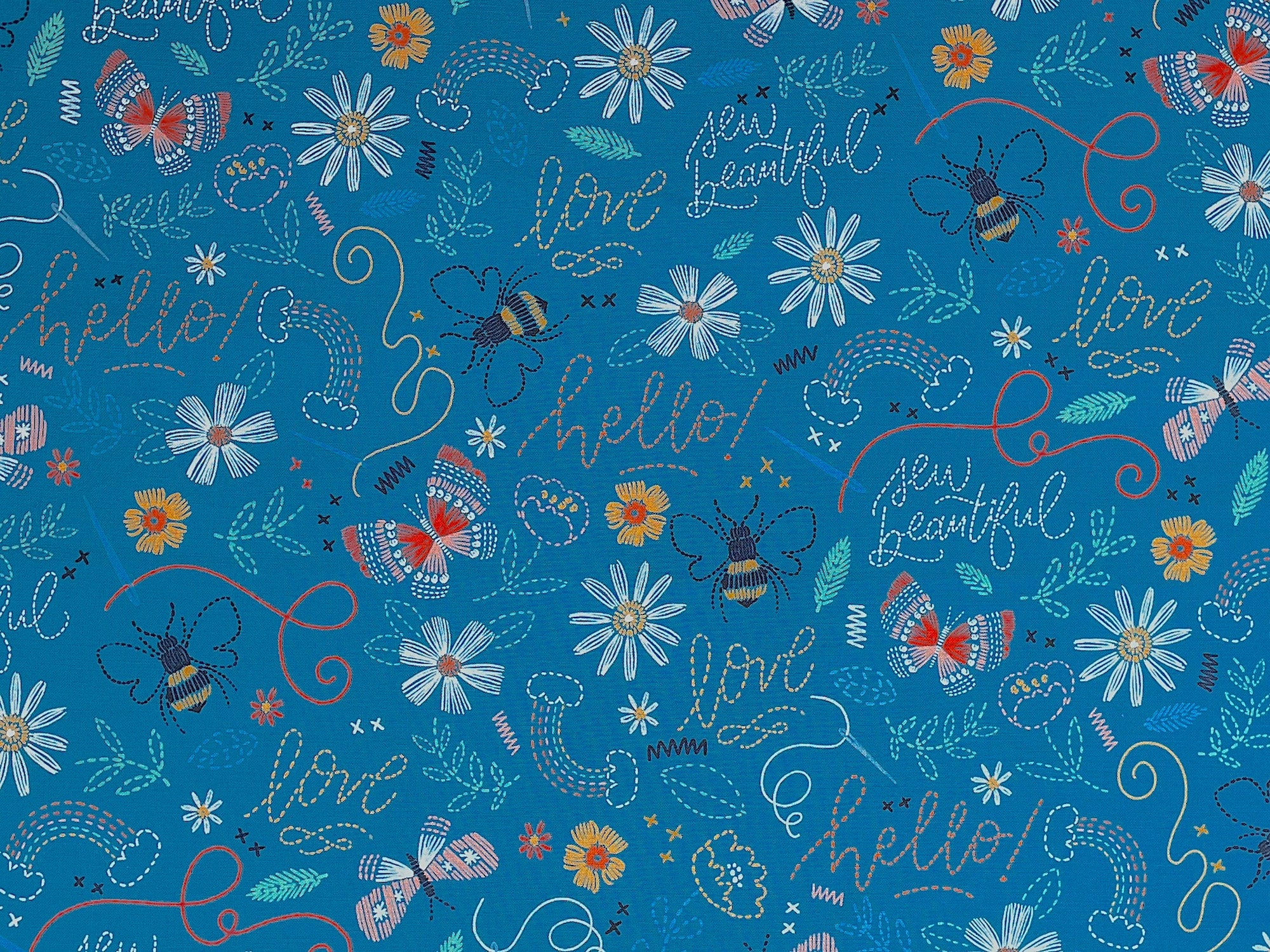 This turquoise blue fabric is covered with bees, butterflies, flowers rainbows and more. You will also find sayings such as love, sew beautiful, hello and more