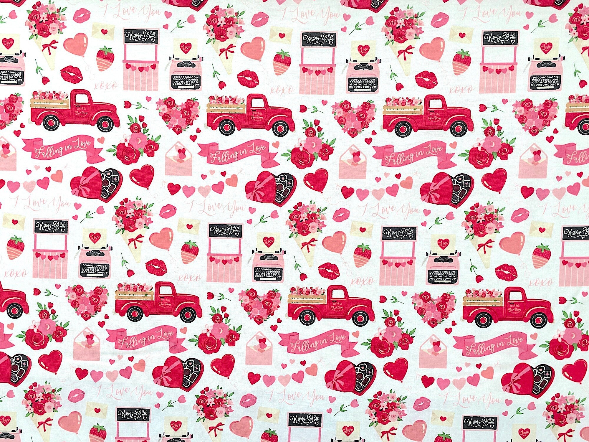 This fabric features an array of hearts, flowers, balloons, love letters, chocolates, trucks, classic Valentine's Day sayings, and other cute pictorials on a white background.