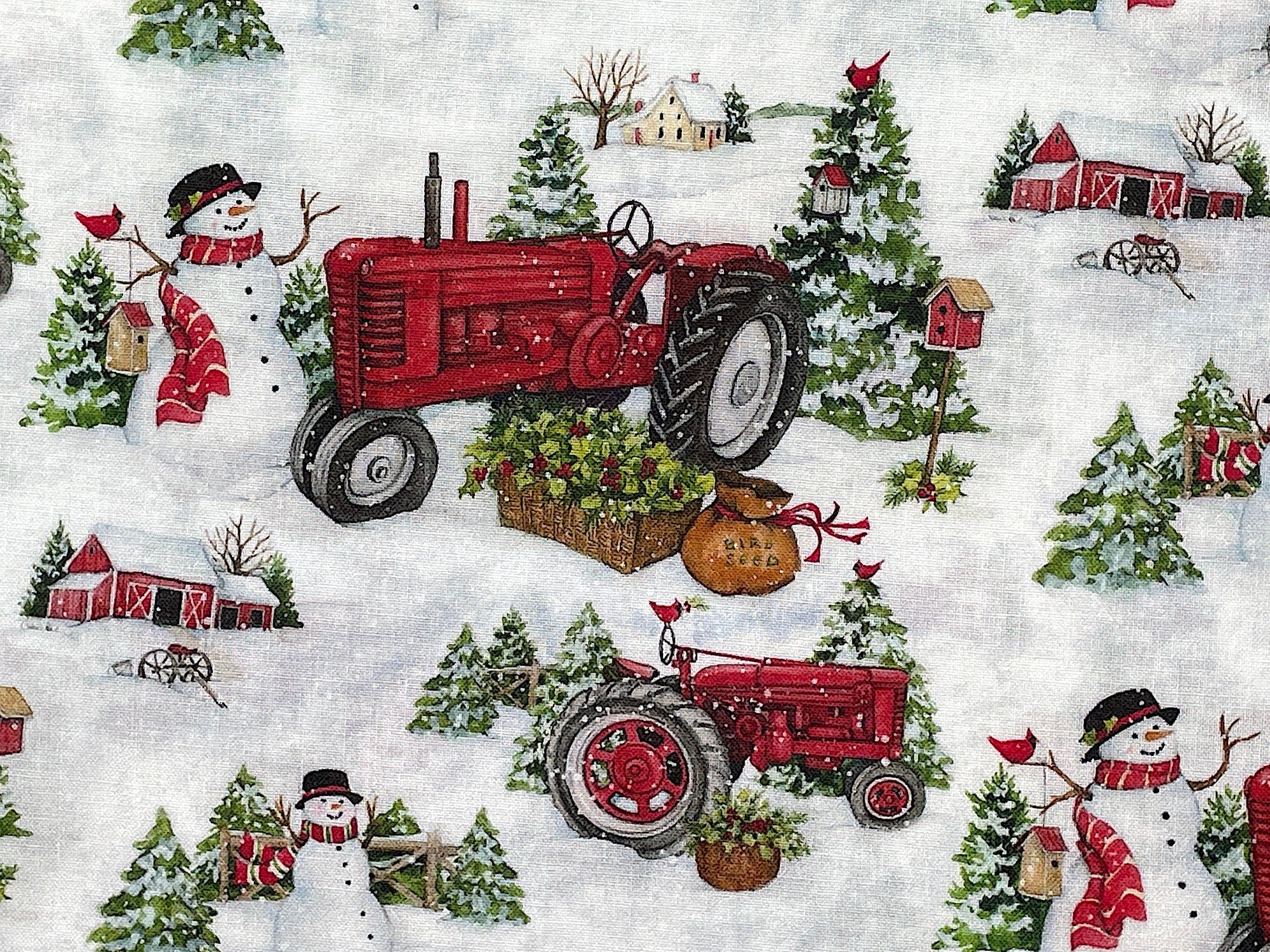 Close up of red tractors, snowmen, trees in the snow.