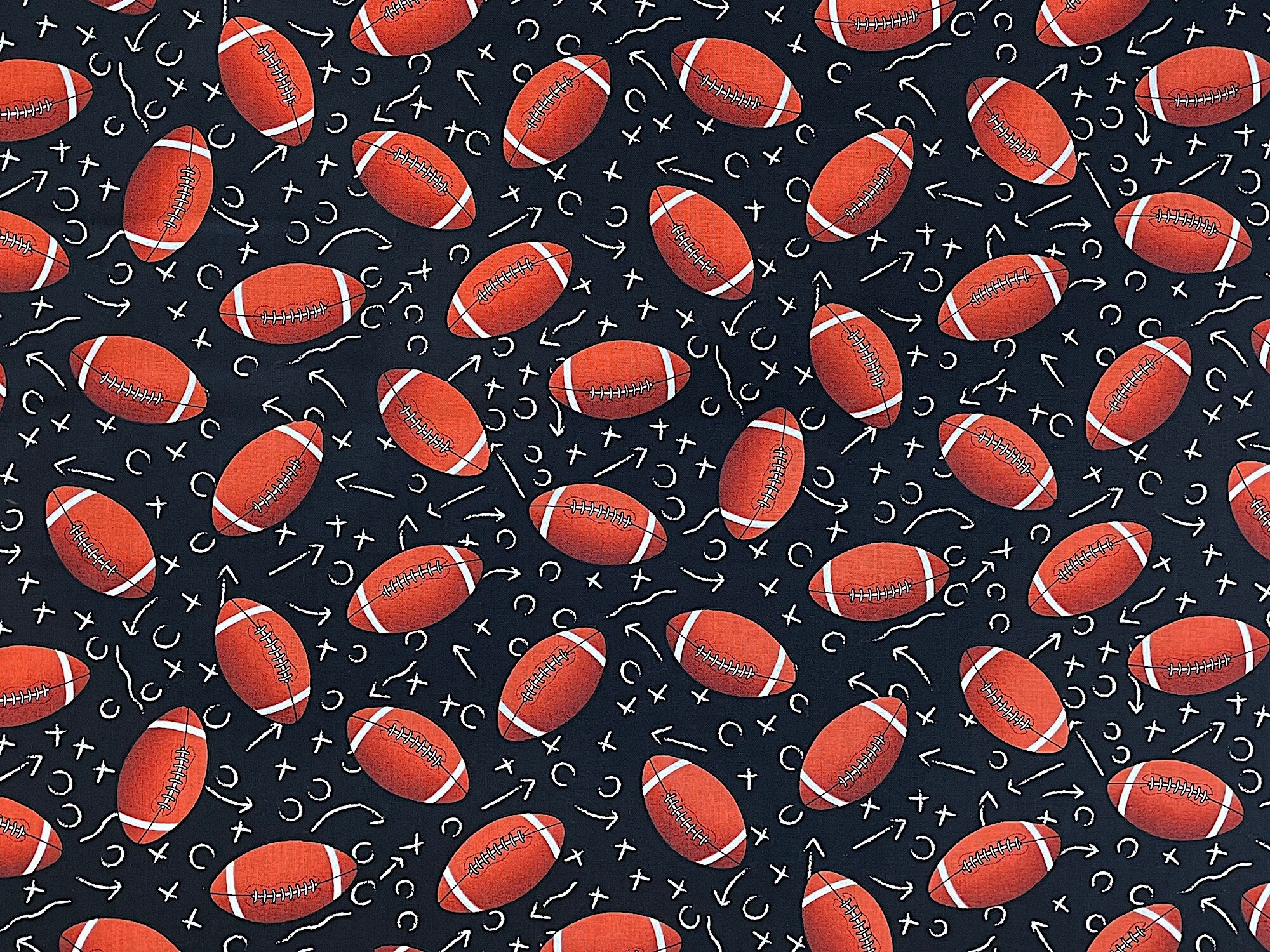 Black cotton fabric covered with footballs.