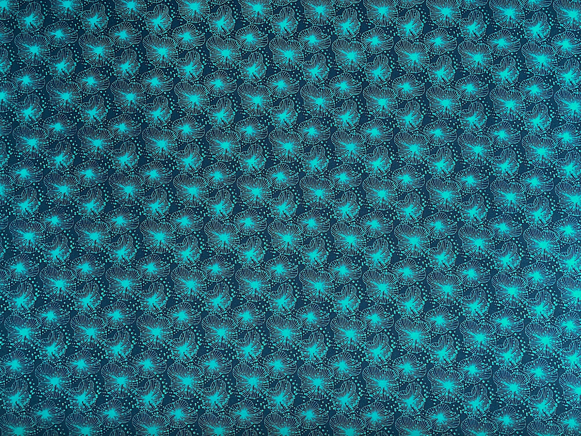 This fabric is part of the Koi Garden collection by Nancy Archer. This dark teal cotton fabric is covered with textured lily pads