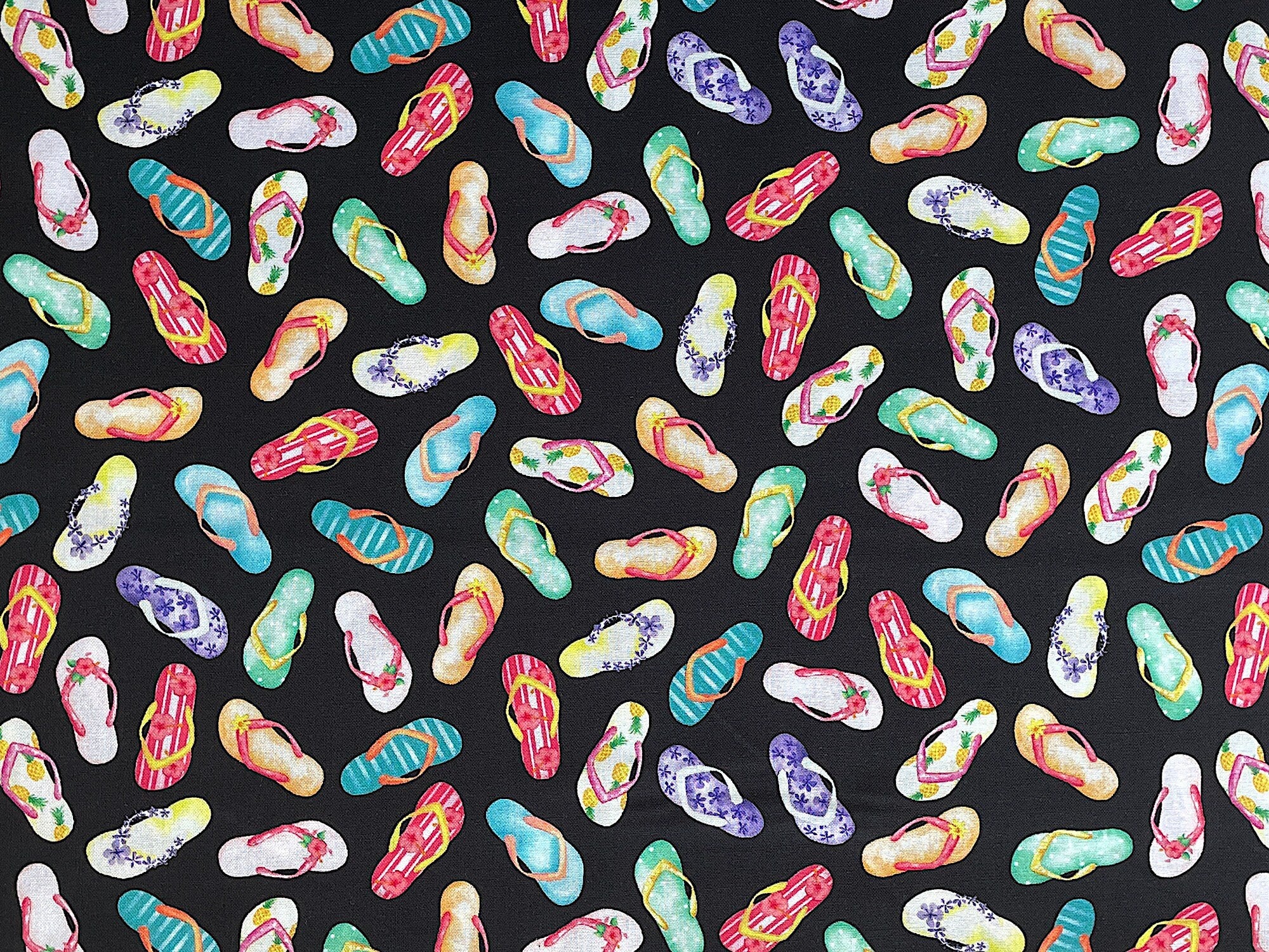 Black cotton fabric covered with colorful flip flops.