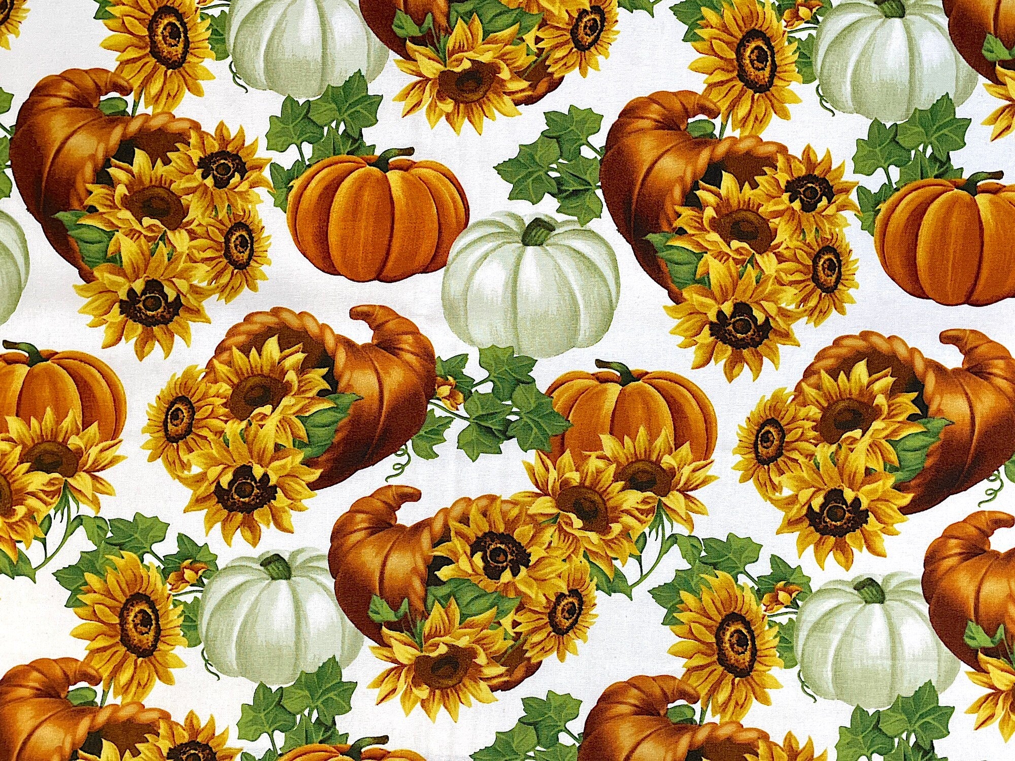 This cotton fabric is covered with cornucopia filled with sunflowers. There are also white and orange pumpkins and ivy throughout the fabric