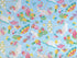 Light blue cotton fabric covered with flamingoes, umbrellas, flowers and more.