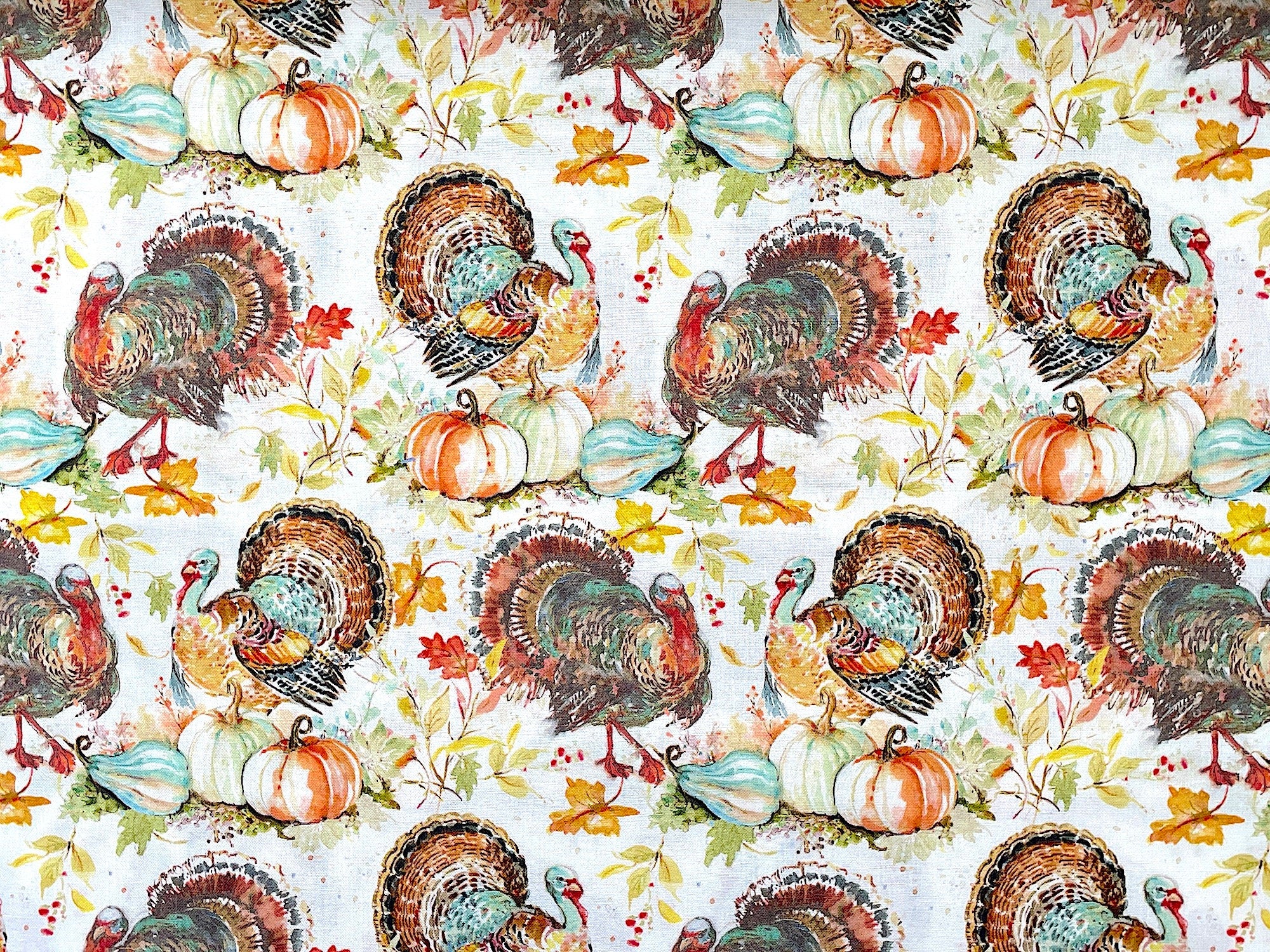 This white cotton fabric is covered with turkeys that are shades of brown, yellow, green and orange. You will find pumpkins and leaves on the ground around the turkeys.