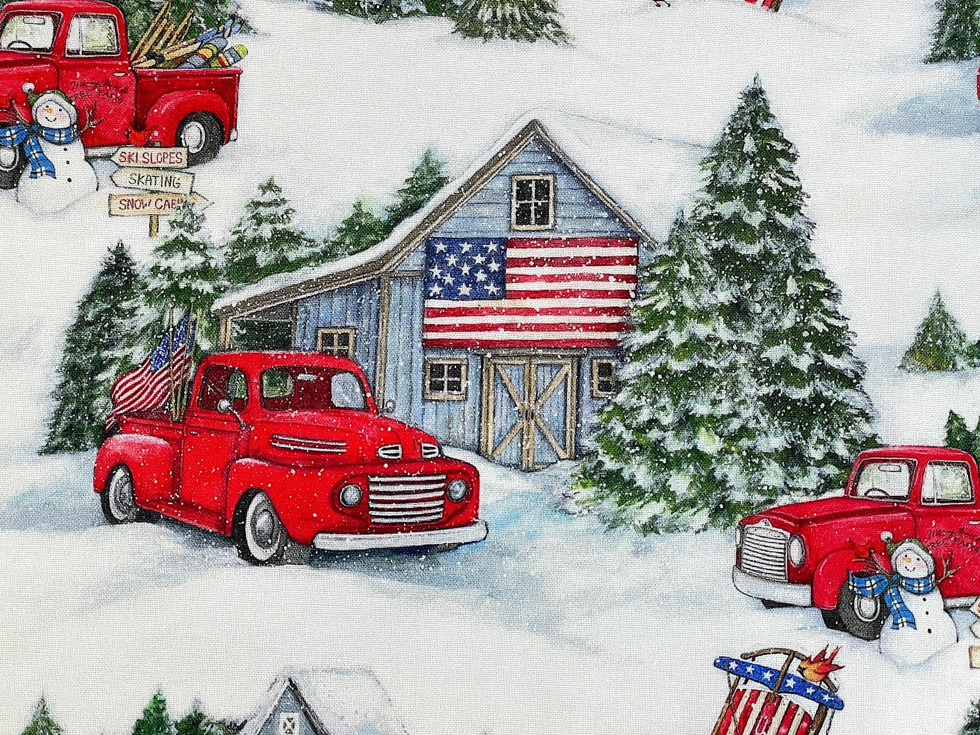 Close up of a red truck in front of a barn that has a USA flag on it.